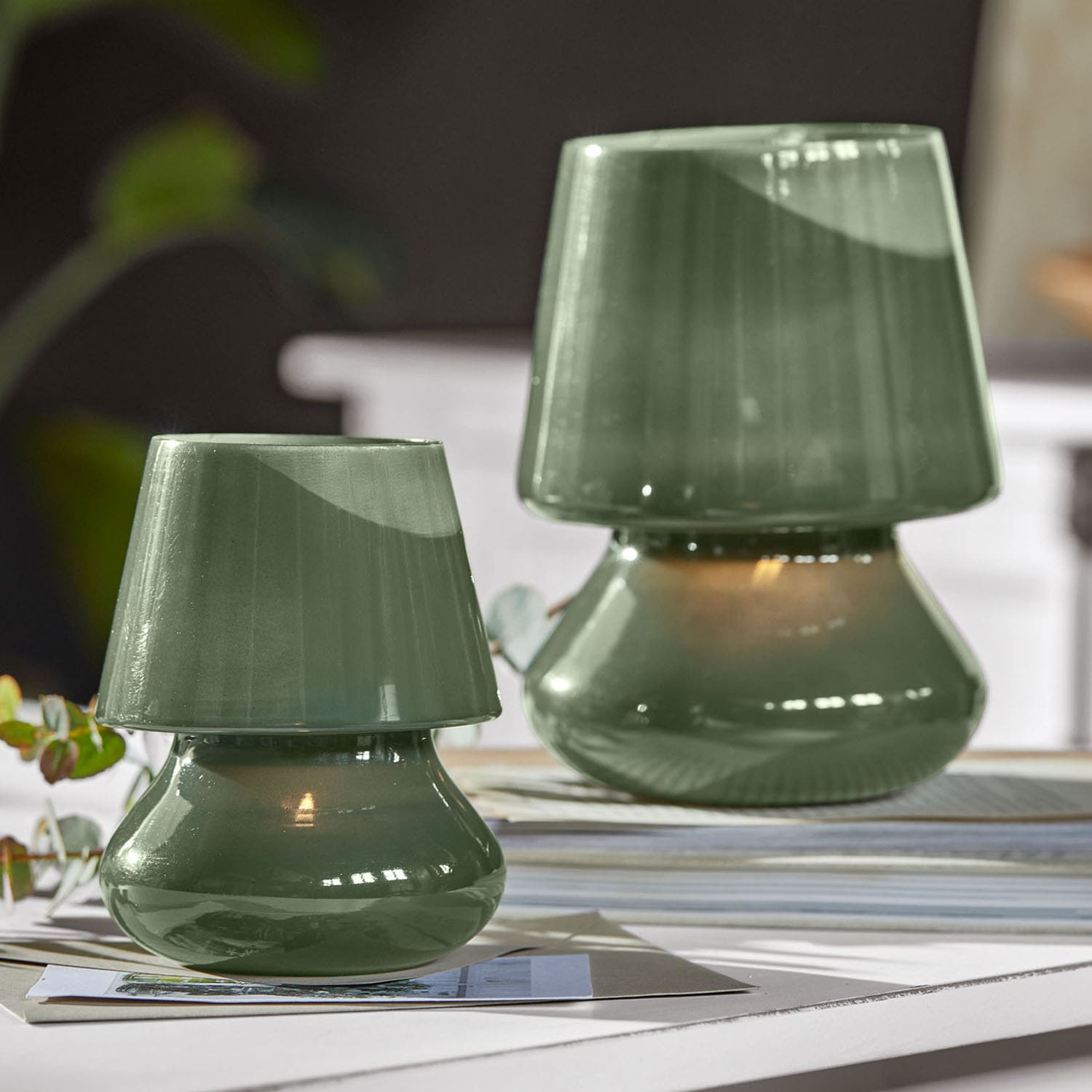 Zielone ceramiczne lampy stołowe o nowoczesnym kształcie na jasnym tle do dekoracji wnętrz