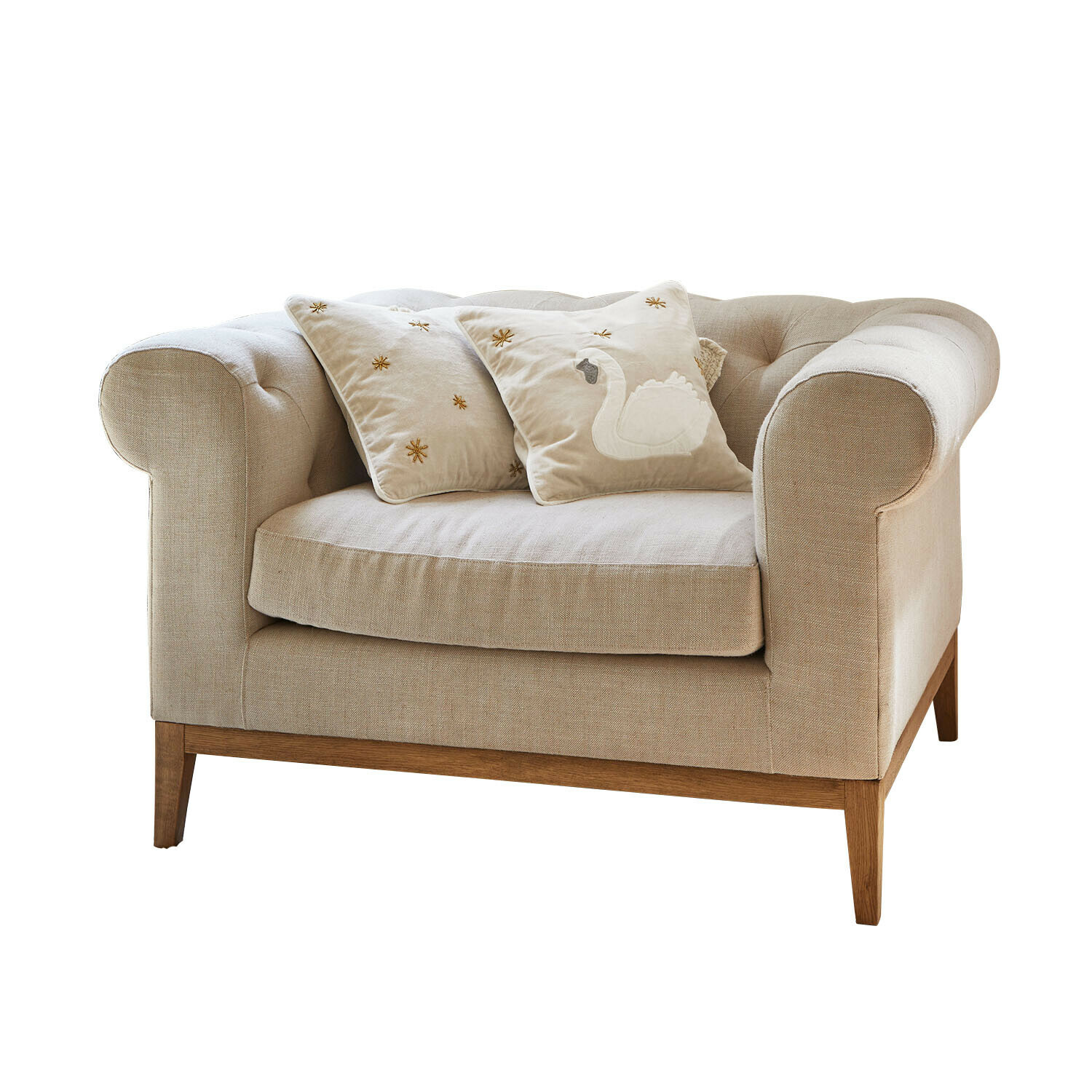 Fotel Fairbourne Beżowa sofa z tkaniny z drewnianą podstawą i dwoma ozdobnymi poduszkami z haftem łabędzia