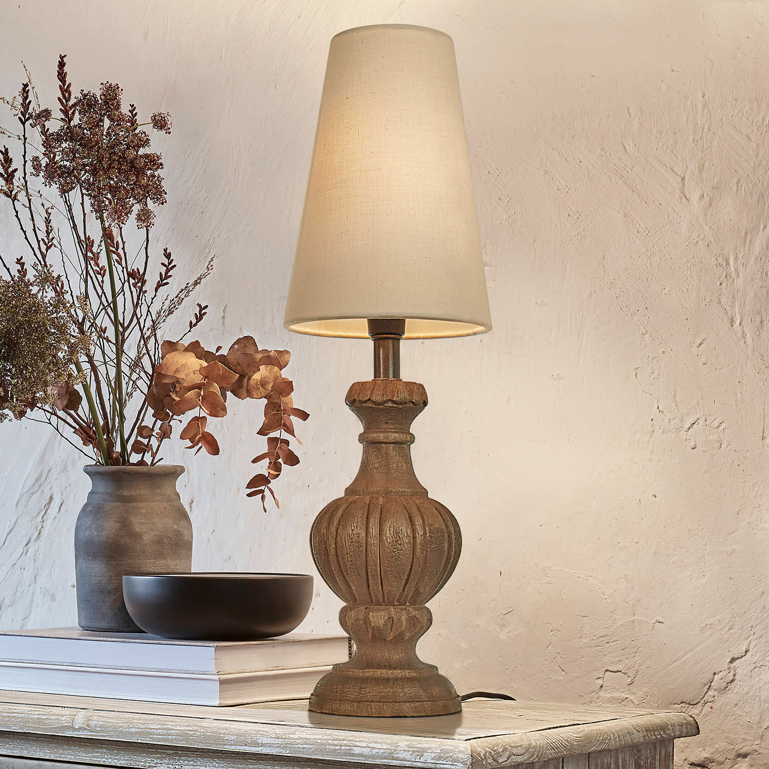 Lampa stołowa Airoux Lampka stołowa z drewnianą podstawą i kremowym abażurem na rustykalnym stole z dekoracją