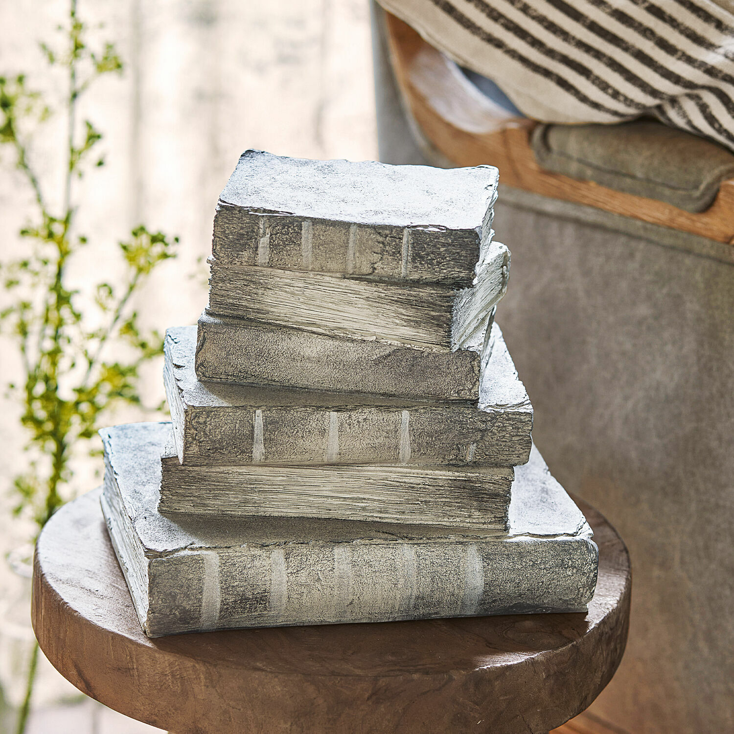 Dekoracyjne sztuczne książki w szarym kolorze na drewnianym stoliku do wnętrz