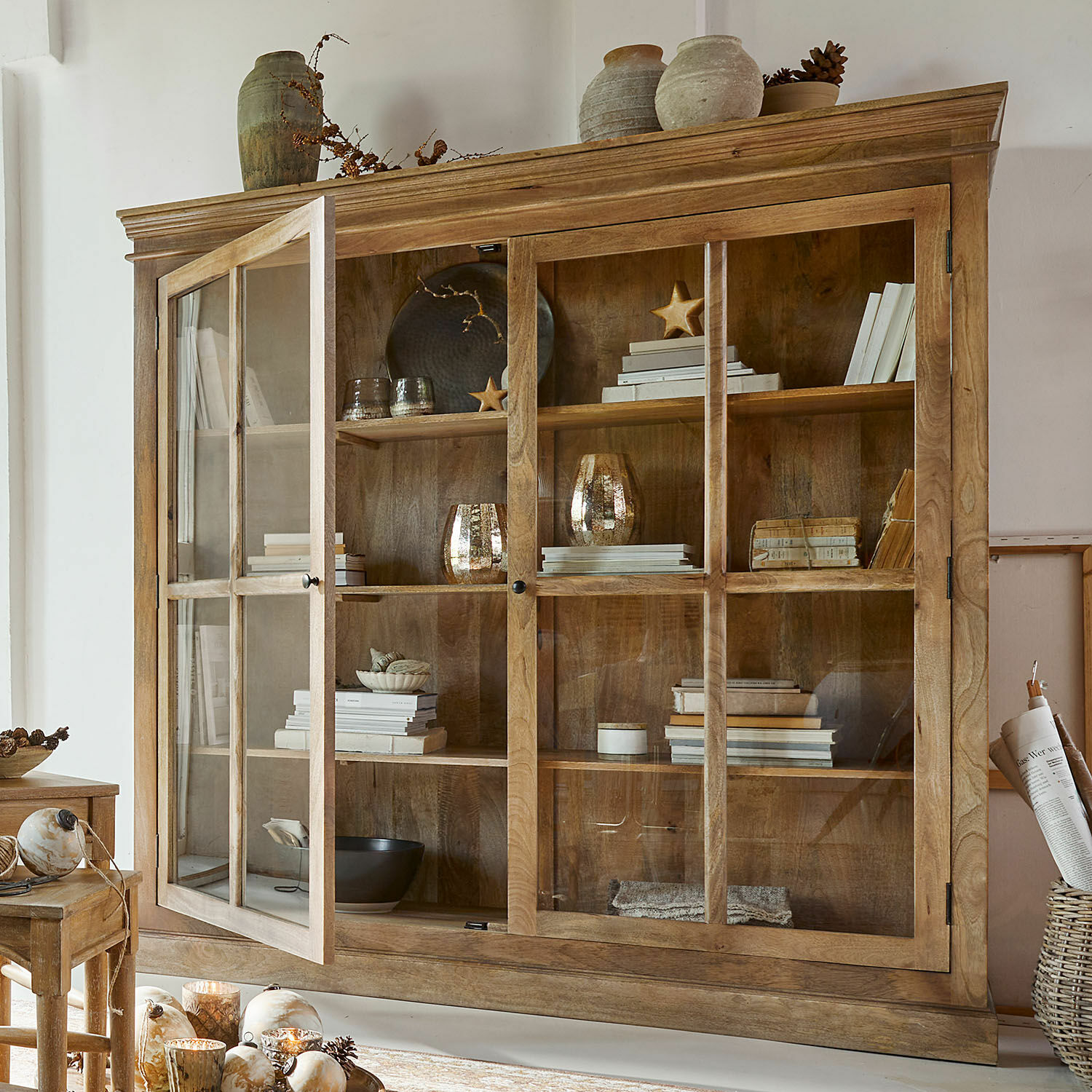 Drewniana witryna z przeszklonymi drzwiami i dekoracjami, naturalny kolor drewna, meble do salonu
