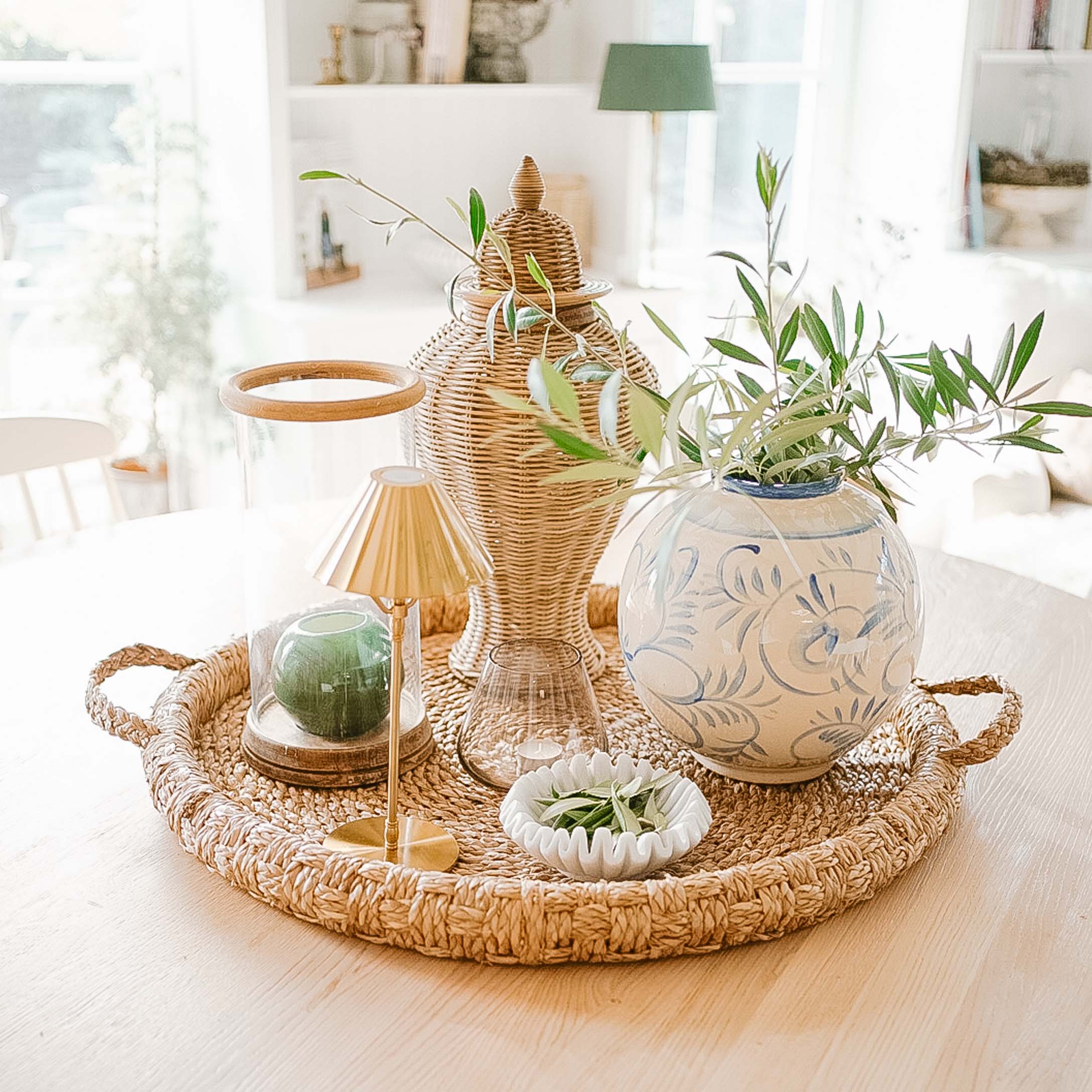 Dekoracyjna taca z rattanu z ceramiczną wazą i zielonymi gałązkami do wnętrz w stylu naturalnym