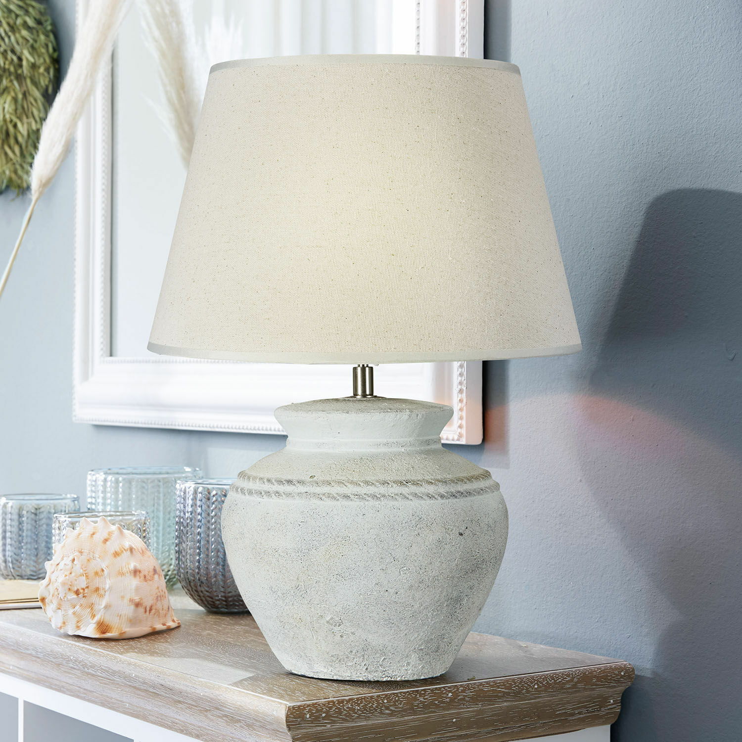 Lampa stołowa Cleveland Lampka stołowa z beżowym abażurem i ceramiczną, szarą podstawą na drewnianym stole