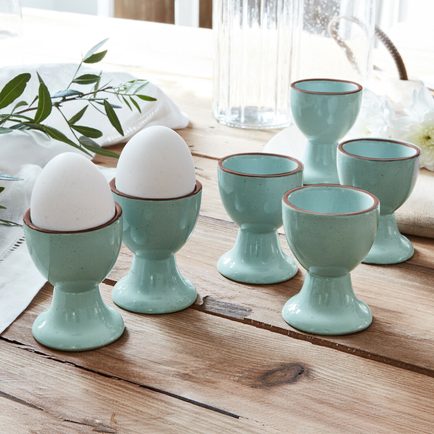 Kieliszek do jajek, zestaw 6 szt. Biarré Zestaw sześciu ceramicznych niebieskich kieliszków na jajka z brązową krawędzią na drewnianym stole