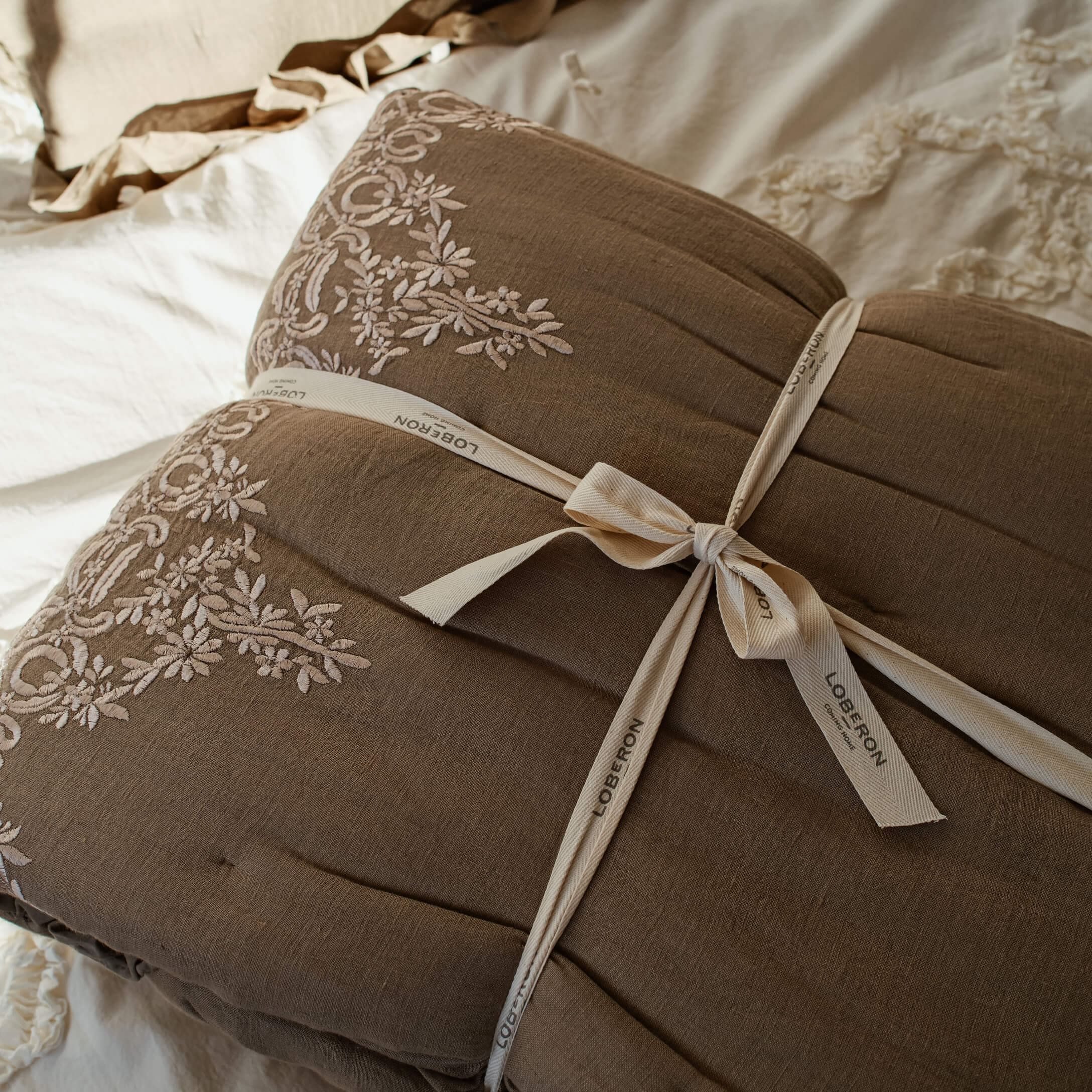 Brązowa pikowana narzuta z haftowanym wzorem i bawełnianą wstążką do dekoracji sypialni