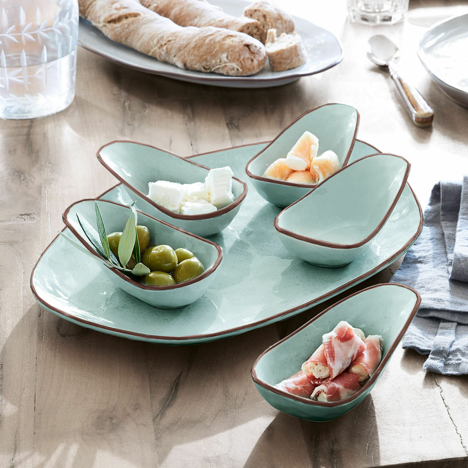 Miseczki do serwowania, zestaw 6 szt. Biarré Zestaw ceramicznych miseczek w miętowym kolorze z brązową krawędzią na przekąski na drewnianym stole