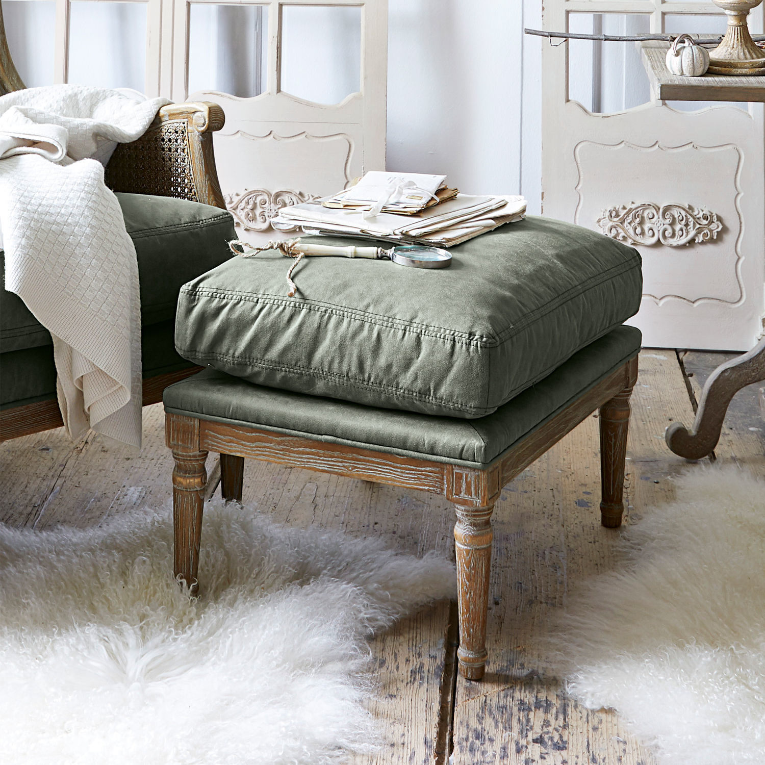 Podnóżek Greenbrier Podnóżek z drewnianą ramą i zielonym materiałowym siedziskiem w stylu vintage w przytulnym wnętrzu