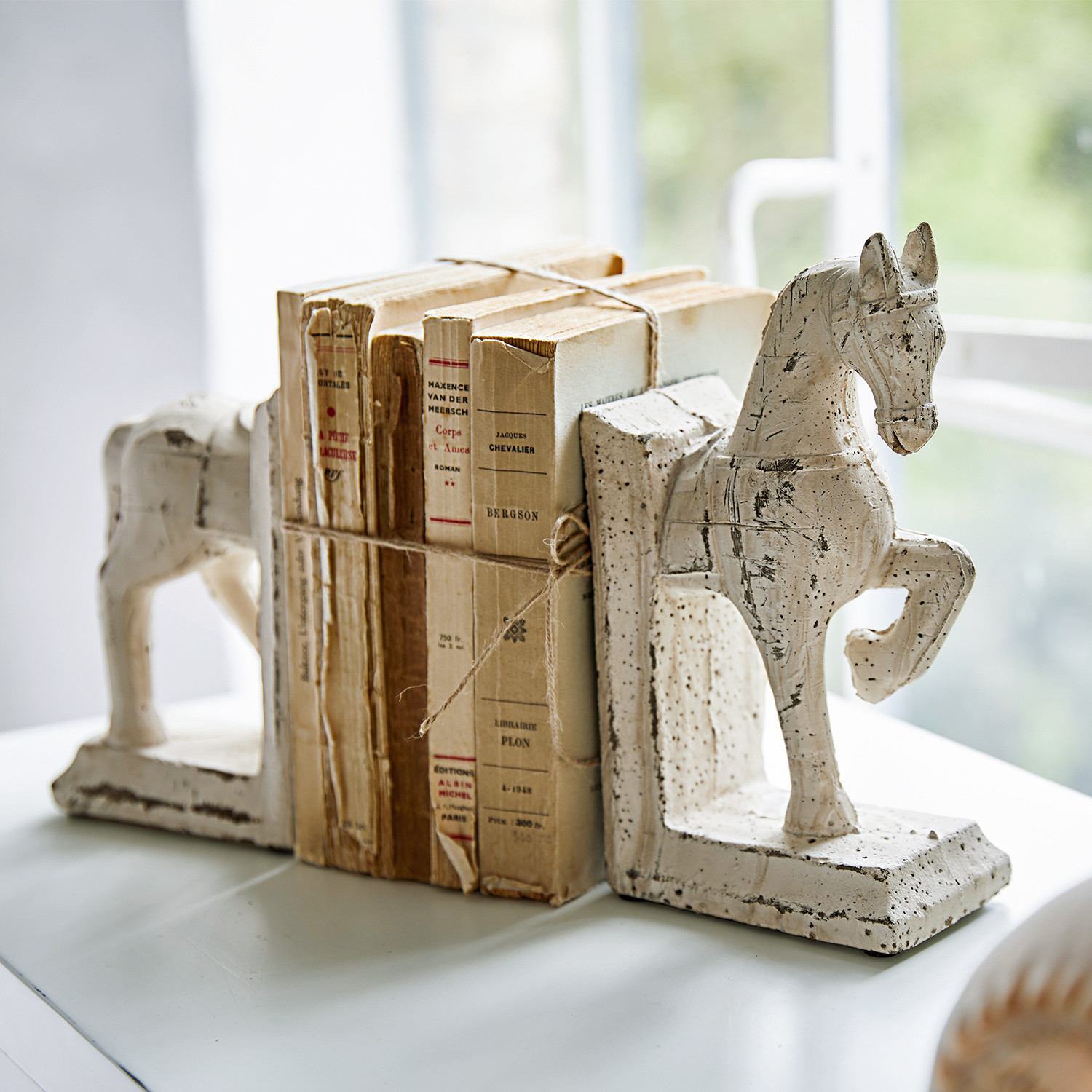 Podpórka do książek, zestaw 2 szt. Horses Białe ceramiczne podpórki do książek w kształcie koni z postarzonymi starymi książkami na stole