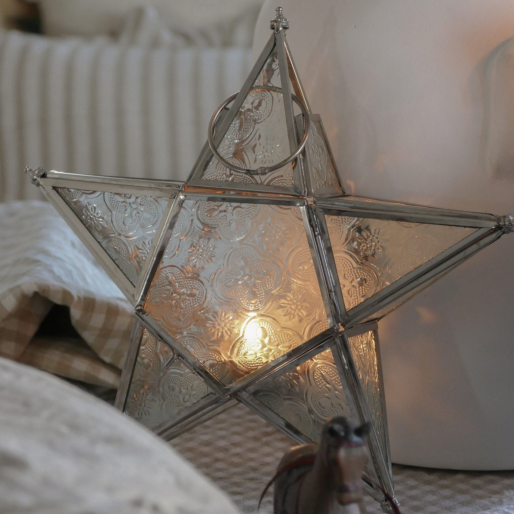 Metalowa gwiazda lampion z ozdobnym wzorem i ciepłym światłem, dekoracja wnętrz na święta