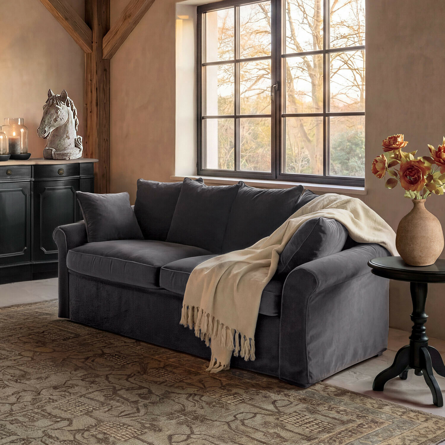 Sofa Long Beach Szara welurowa sofa z kremowym kocem w przytulnym salonie z dekoracją konia i kwiatami