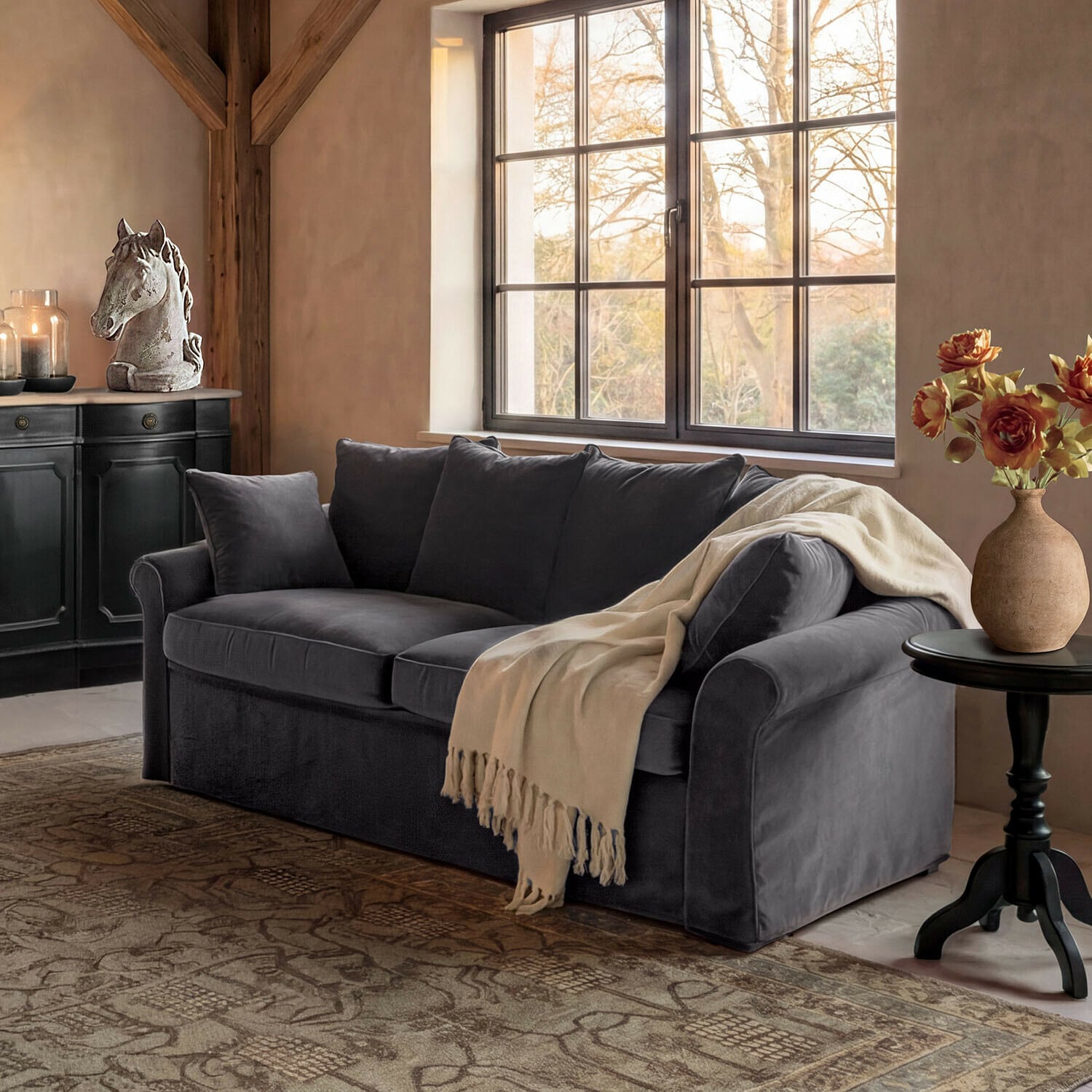 Sofa Long Beach Szara welurowa sofa z kremowym kocem w przytulnym salonie z dekoracją konia i kwiatami