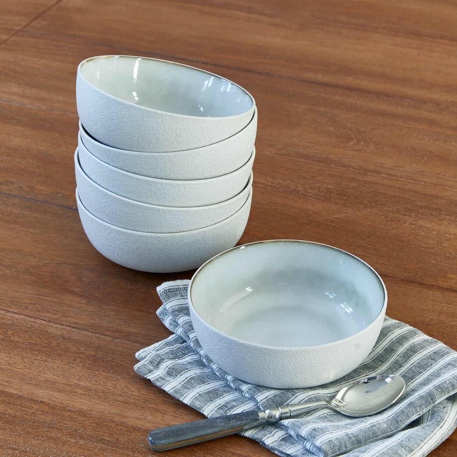 Miska, zestaw 6 szt. Eiruna Zestaw białych ceramicznych misek o matowej fakturze na drewnianym stole z łyżką i ściereczką