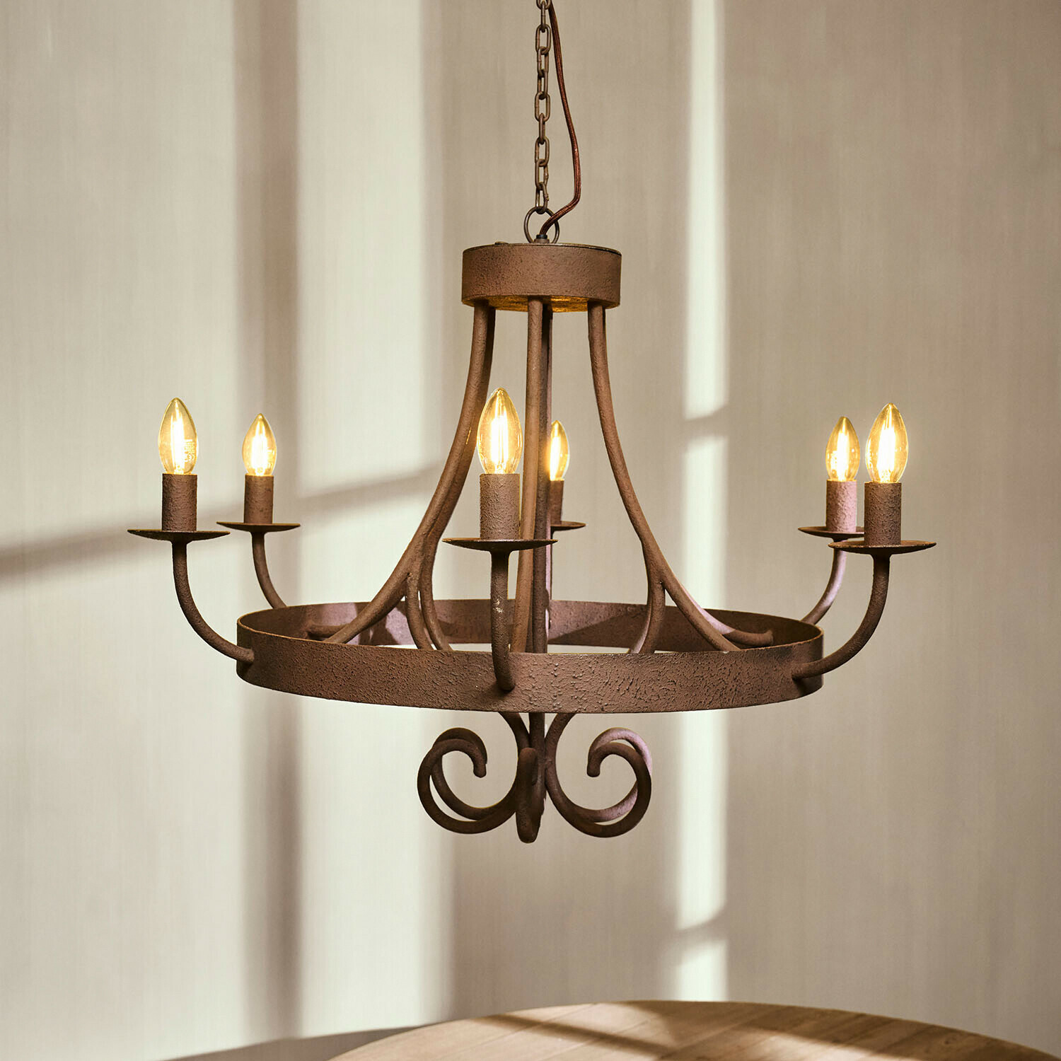 Rustykalny żyrandol z metalu w kolorze rdzy z sześcioma żarówkami w kształcie świec, oświetlenie wnętrza