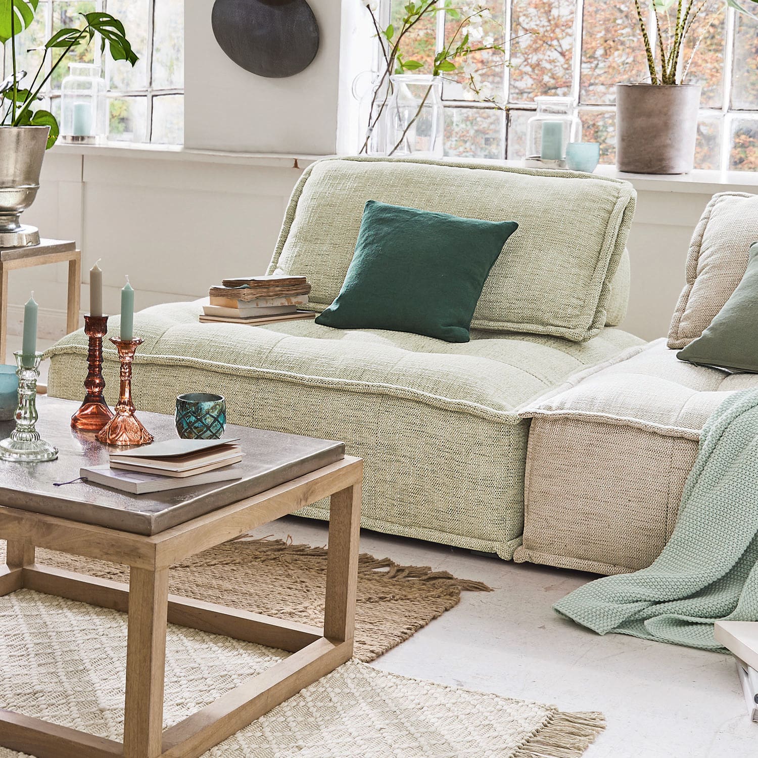 Puf modułowy Tesshill Jasnozielona tapicerowana sofa z poduszką i drewnianym stolikiem kawowym w nowoczesnym salonie