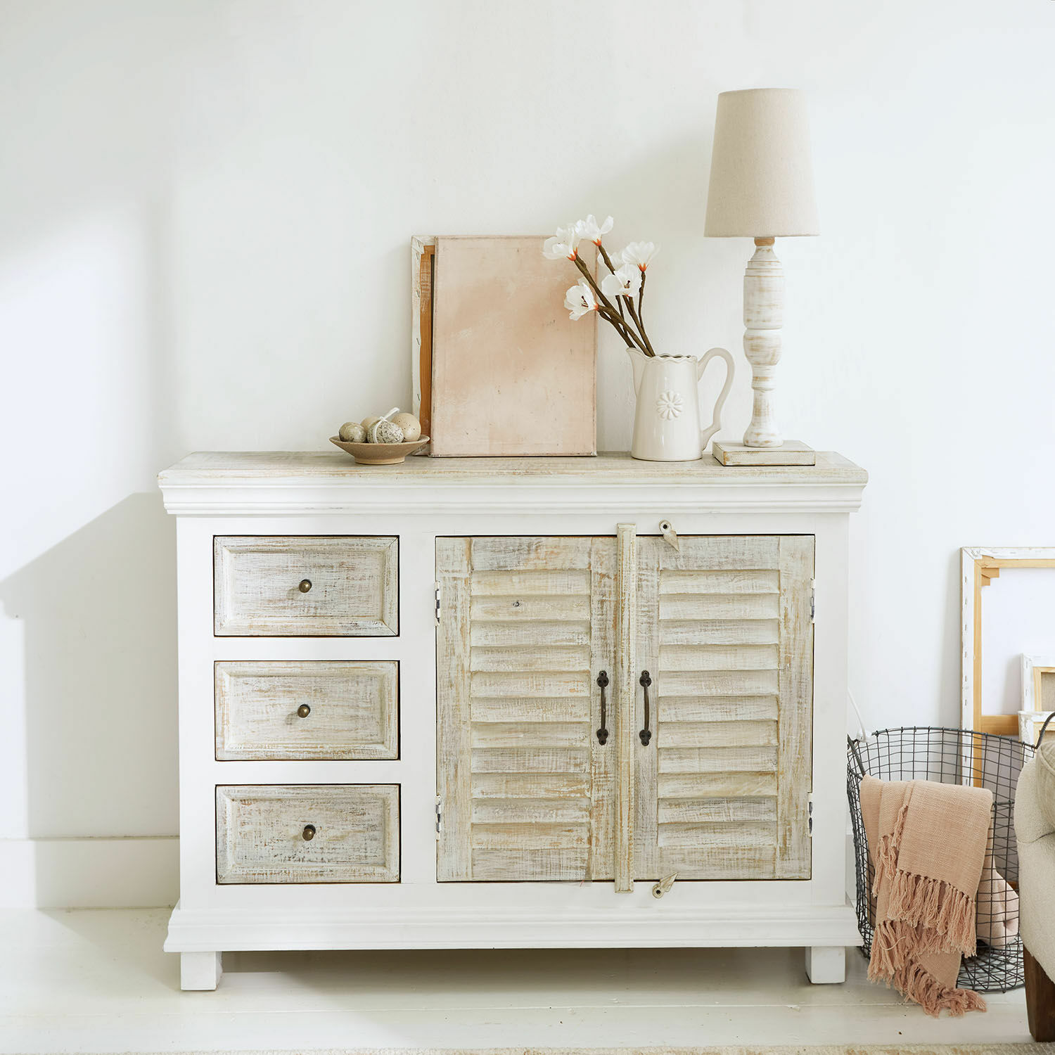 Komoda z szufladami Nevellique Biała drewniana komoda z trzema szufladami i dwuskrzydłowymi drzwiami w stylu vintage
