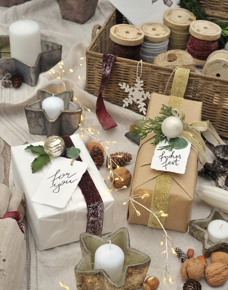 Elegancko zapakowane prezenty z papieru kraft i białego, ozdobione wstążkami i naturalnymi dekoracjami