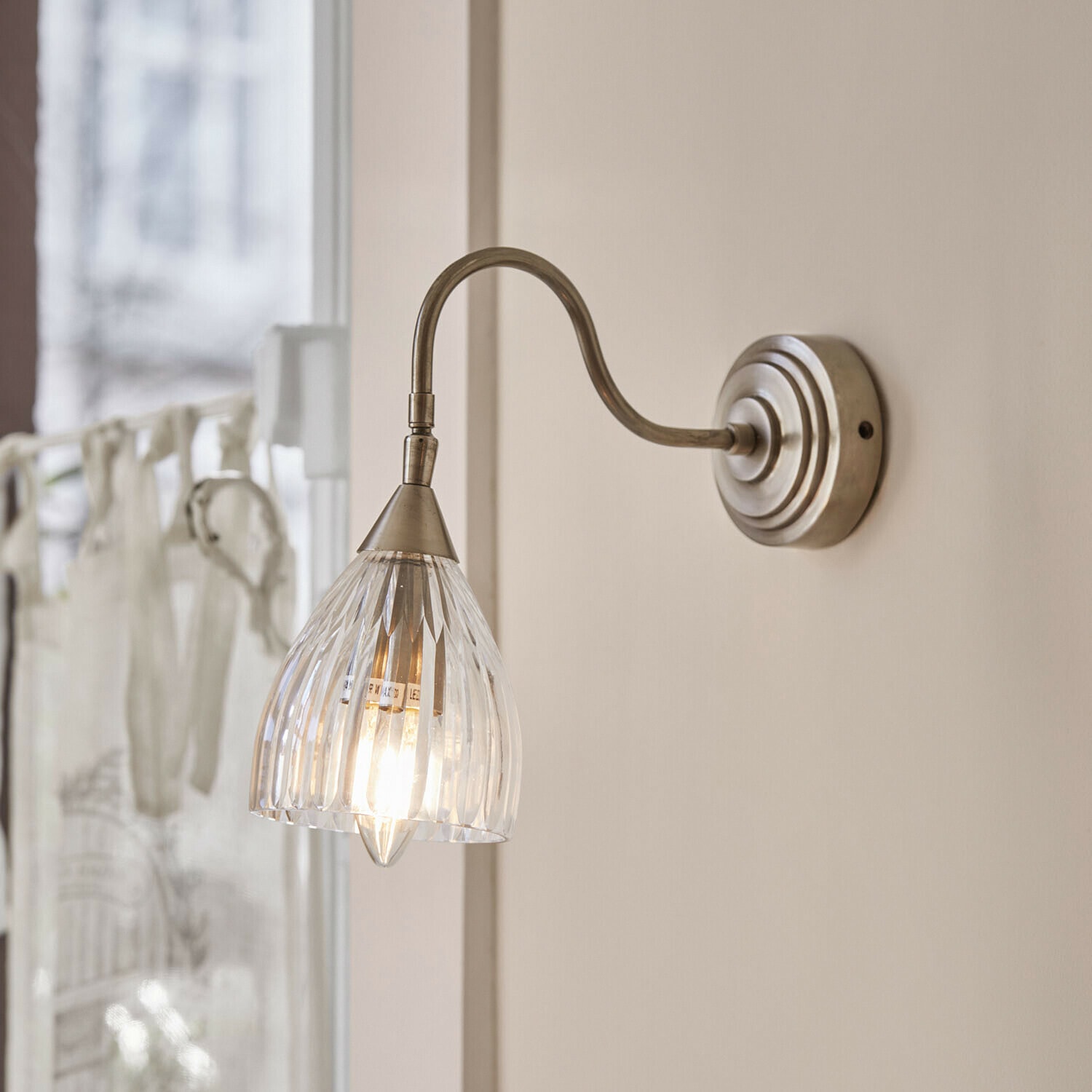 Lampa ścienna Niamhs Kinkiet ścienny z przezroczystym szklanym kloszem i metalowym ramieniem w kolorze starego srebra