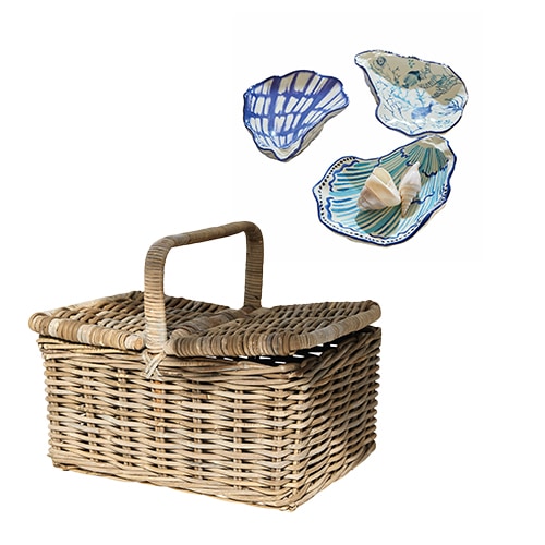 Kosz piknikowy z rattanu w naturalnym kolorze z ceramicznymi talerzami w niebieskie wzory