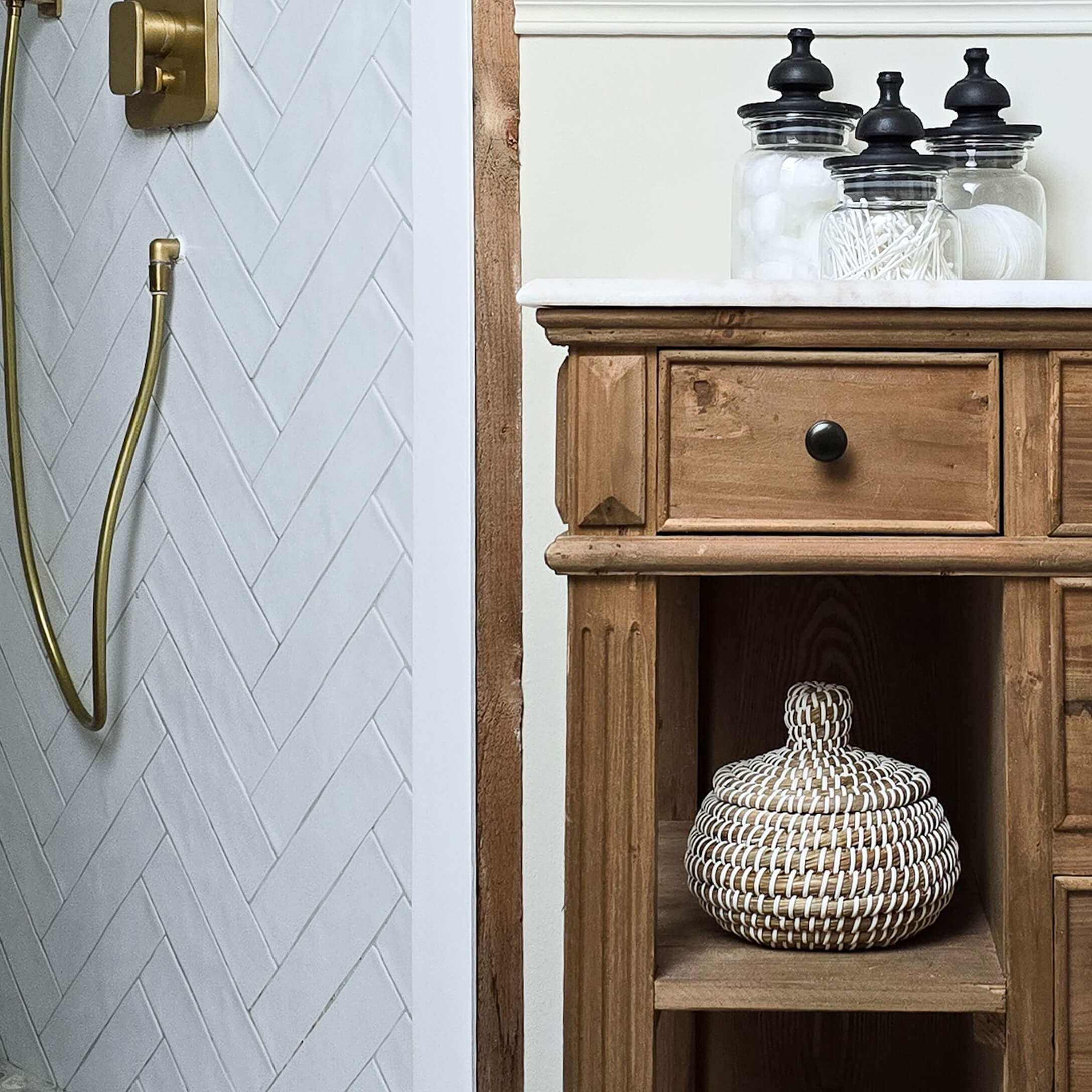 Drewniana szafka łazienkowa z białym blatem i szklanymi pojemnikami na akcesoria w stylu rustykalnym