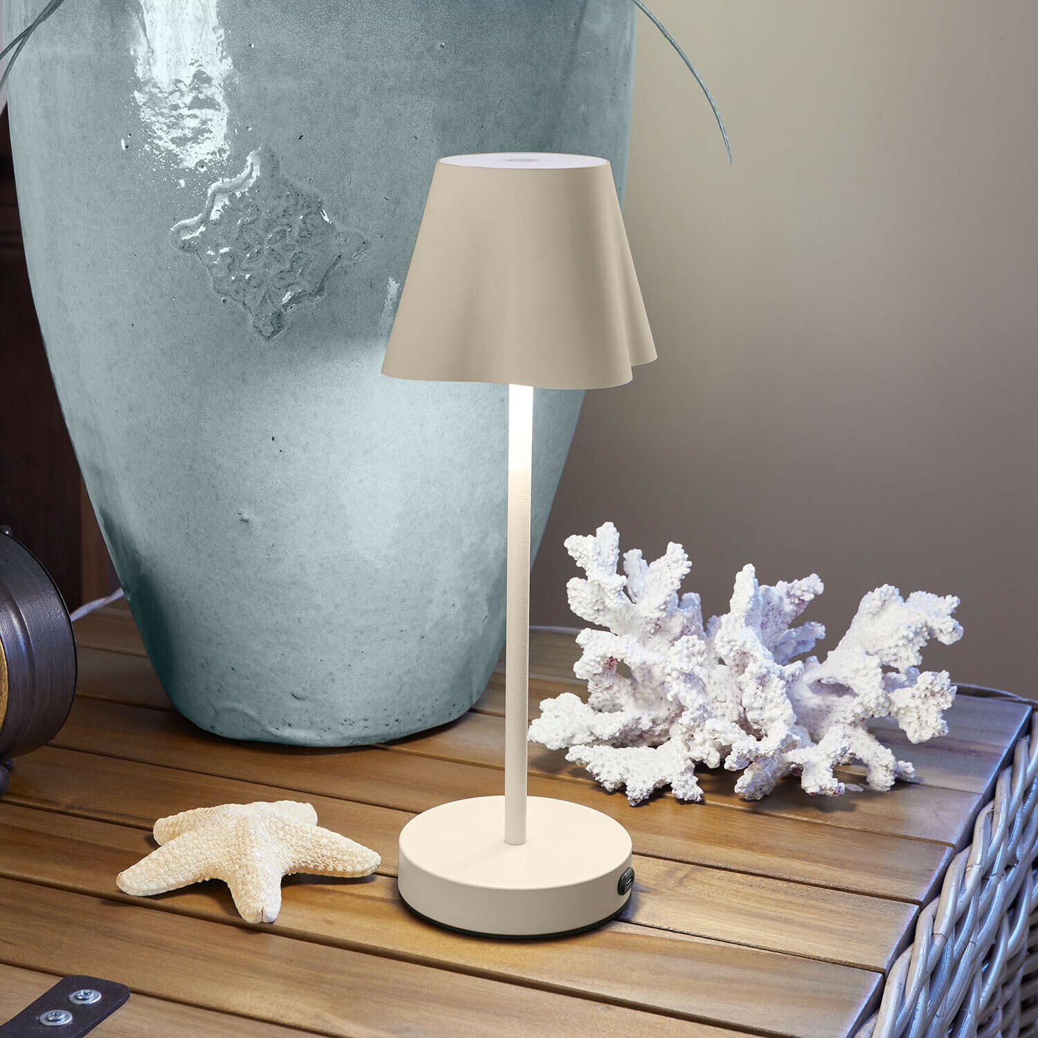 Lampa stołowa do ładowania Tenari Beżowa lampka stołowa z metalu na drewnianym stole z dekoracją morską i dużym wazonem