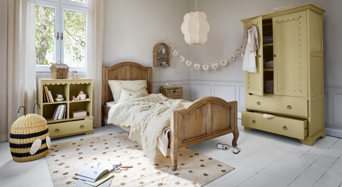 Przytulny pokój dziecięcy z drewnianym łóżkiem i żółtą szafą oraz meblami w stylu pszczelim