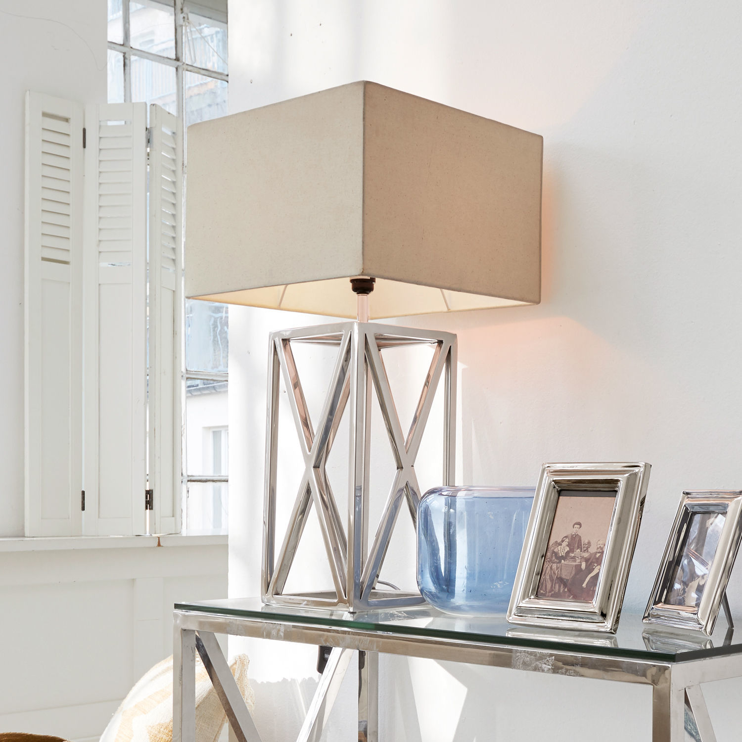 Lampa stołowa Foix Nowoczesna lampa stołowa z metalową podstawą i beżowym abażurem na szklanym stole w jasnym wnętrzu