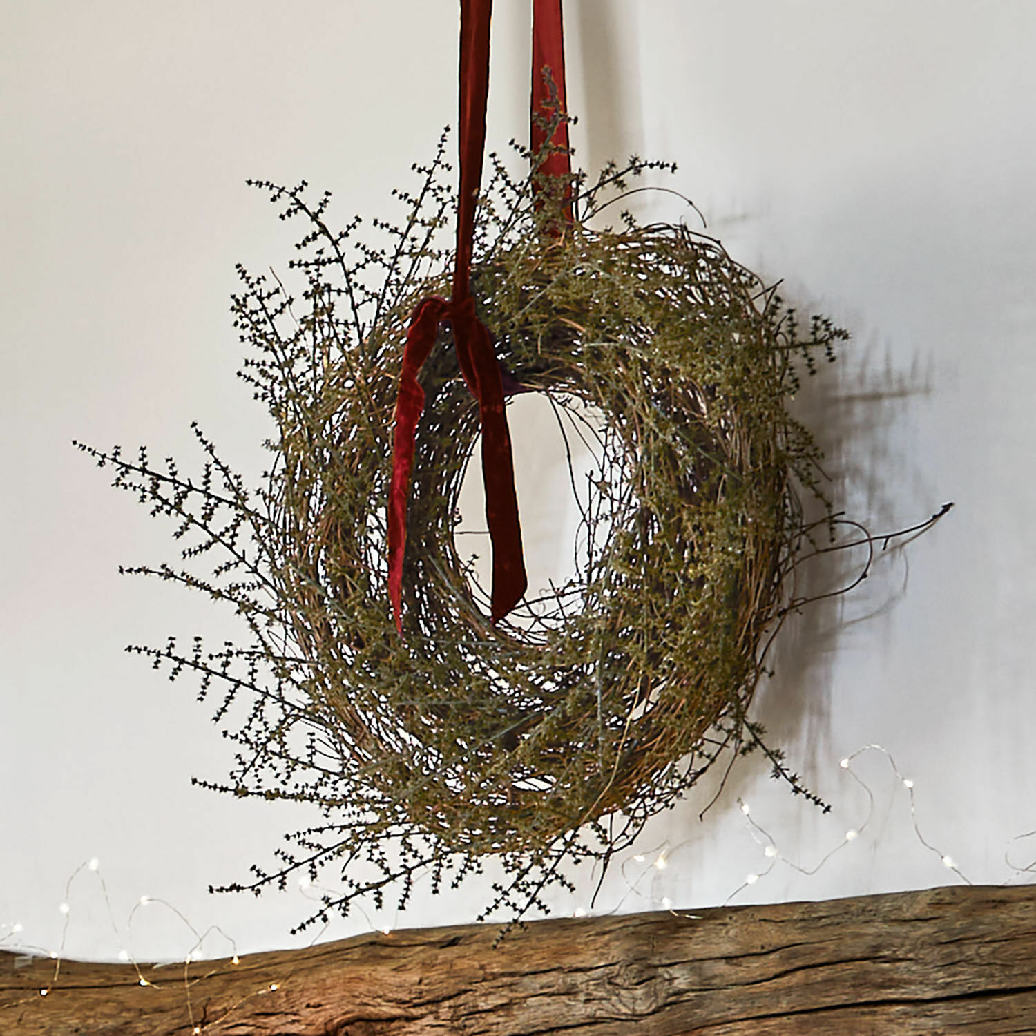 Naturalny wieniec z gałązek z czerwonym aksamitnym wstążką do dekoracji ścian i wnętrz