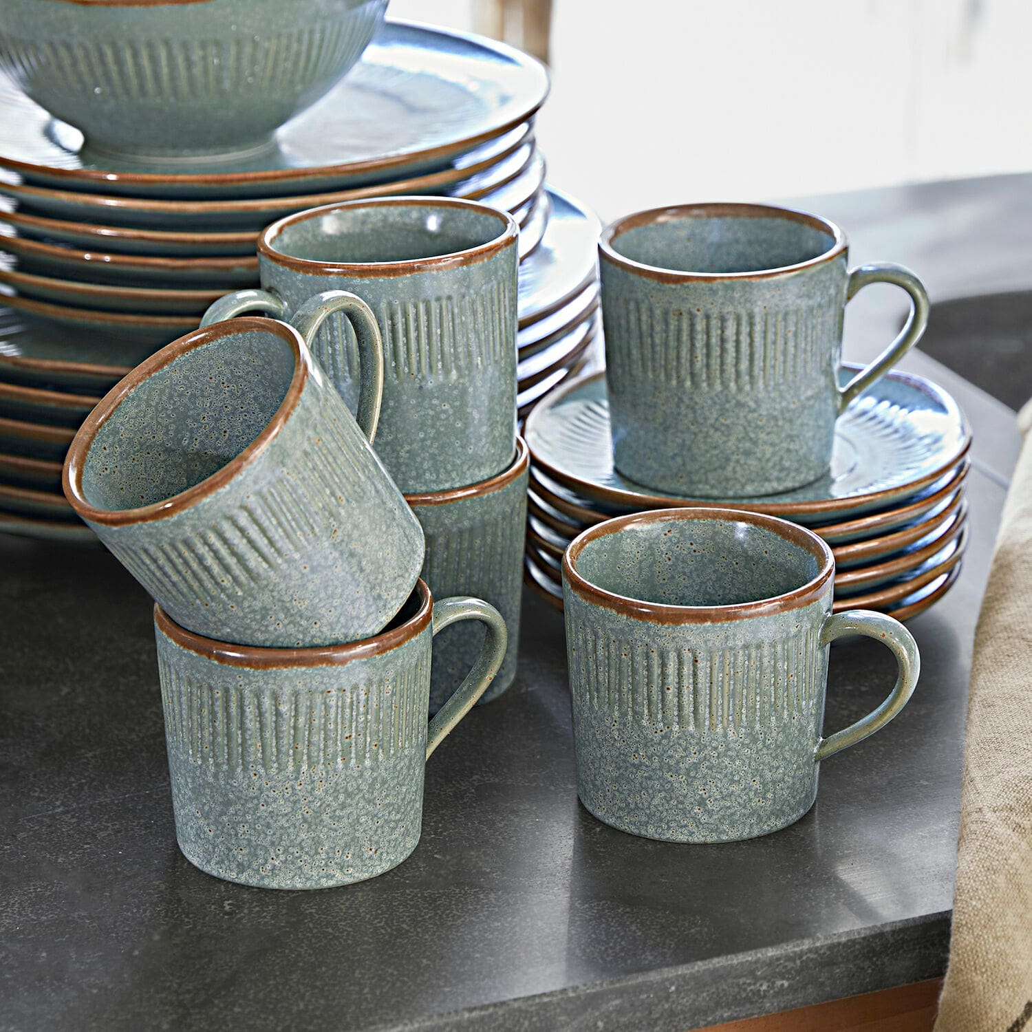 Filiżanka ze spodkiem, zestaw 6 szt. Périers Zestaw ceramicznych kubków i talerzy w zielonym odcieniu z brązowym rantem na kuchennym blacie