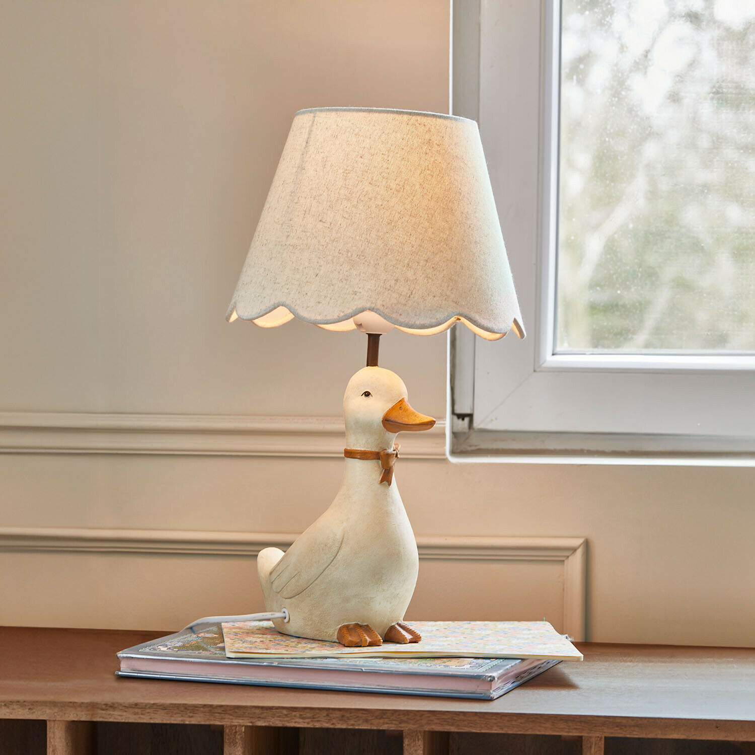 Lampa do pokoju dziecięcego Tillyboo Lampka stołowa z białą podstawą w kształcie kaczki i beżowym abażurem z falowanym brzegiem