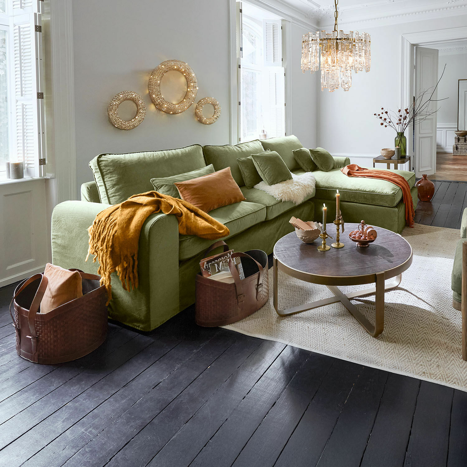 Sofa Seaford Przytulny zielony narożnik z miękkiego materiału w salonie z drewnianą podłogą i dekoracyjnym oświetleniem