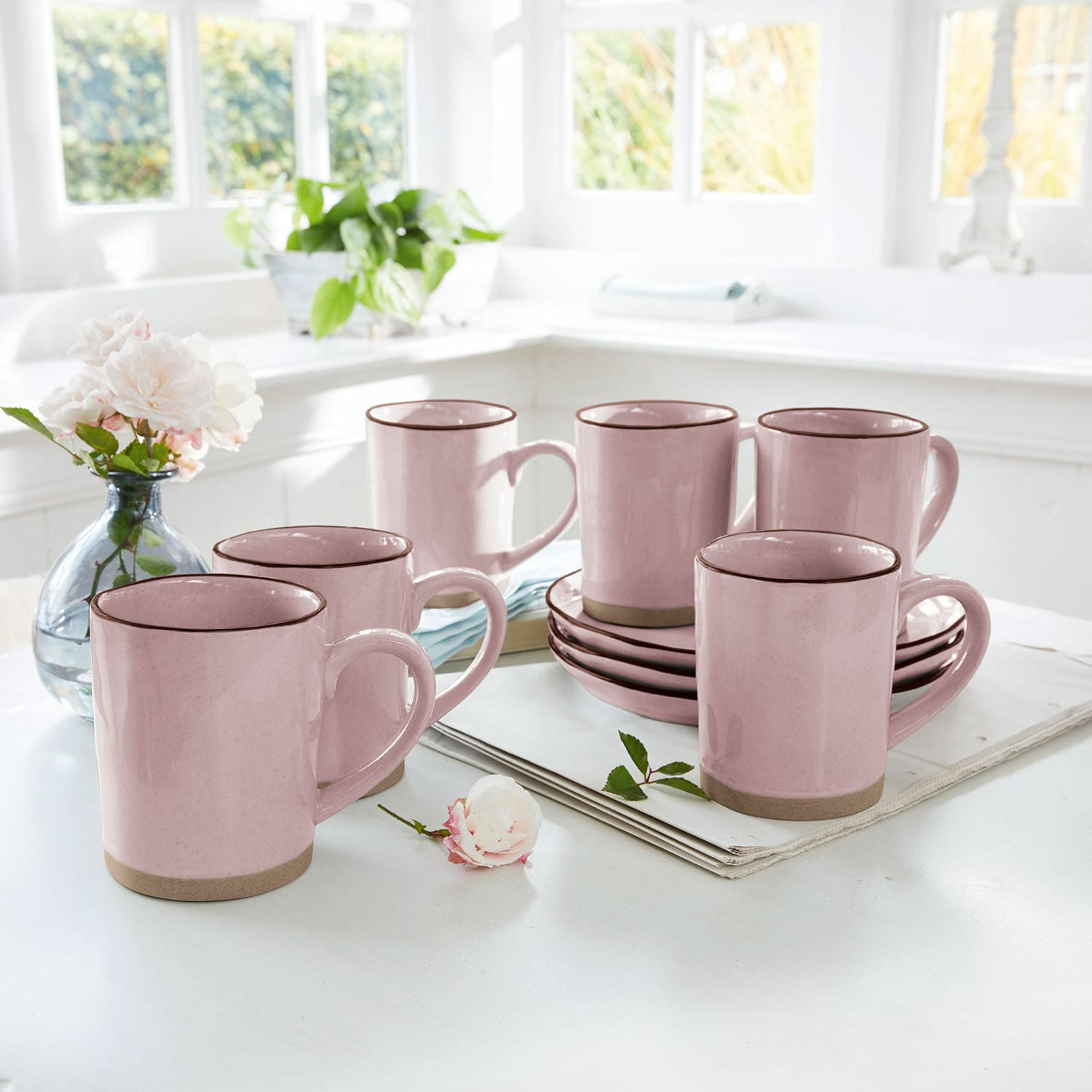 Filiżanka, zestaw 6 szt. Biarré Zestaw różowych ceramicznych kubków z brązowym rantem i spodkami na jasnym stole w kuchni