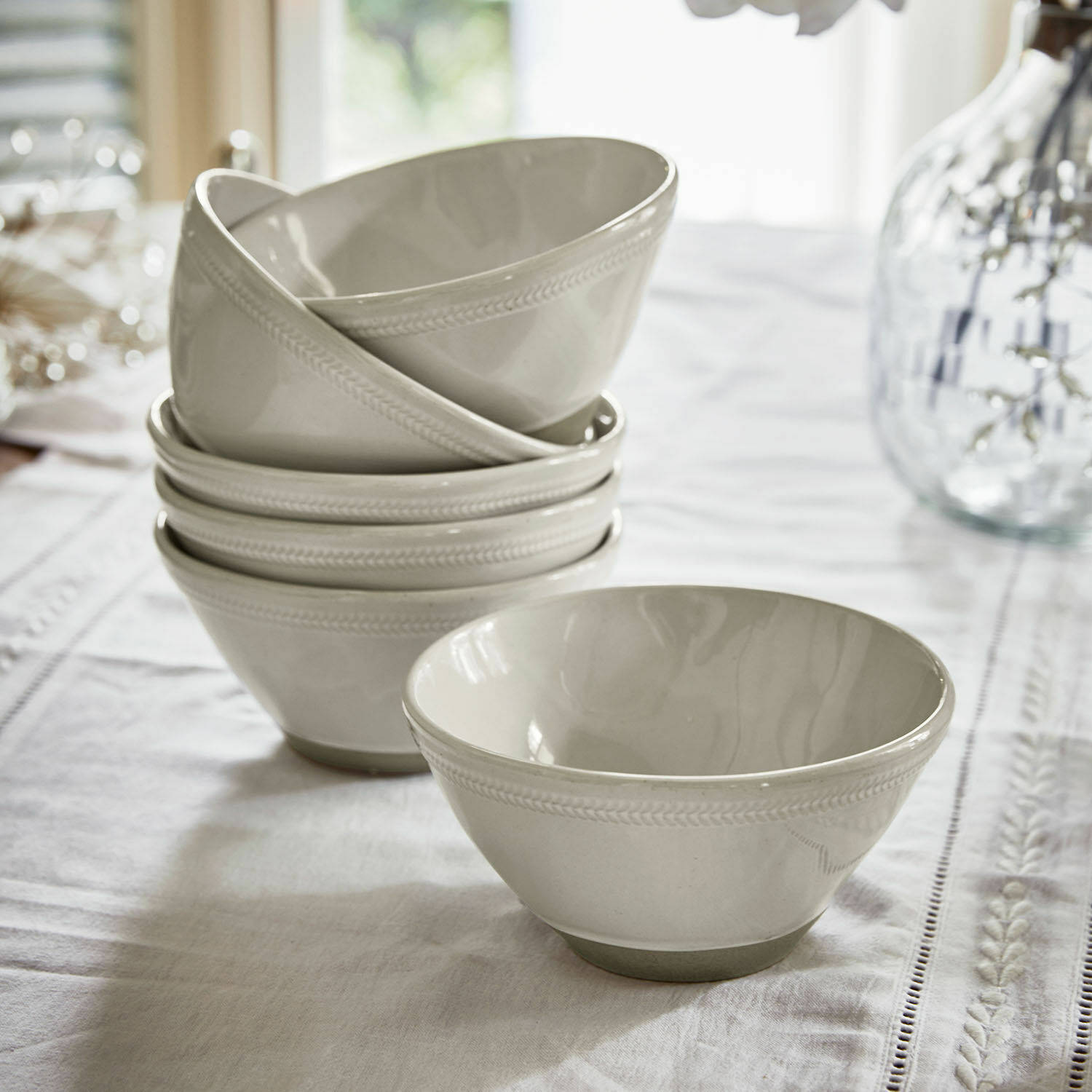 Miska, zestaw 6 szt. Norrvik Zestaw białych ceramicznych misek z delikatnym wzorem na krawędzi na stole z obrusem