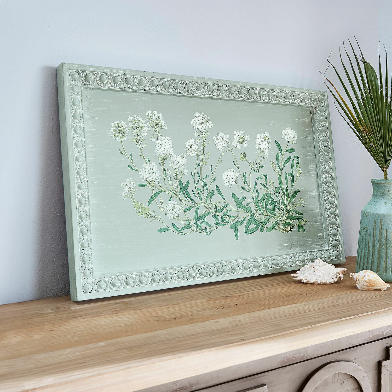 Dekoracyjna zielona drewniana ramka z białymi kwiatami na drewnianym blacie, dekoracja wnętrz