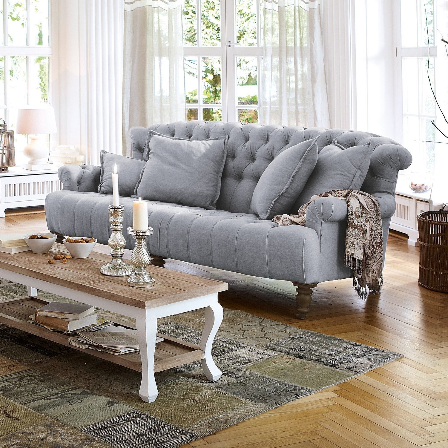 Sofa Springfield Village Szara tapicerowana sofa z poduszkami i drewnianym stolikiem kawowym w jasnym salonie