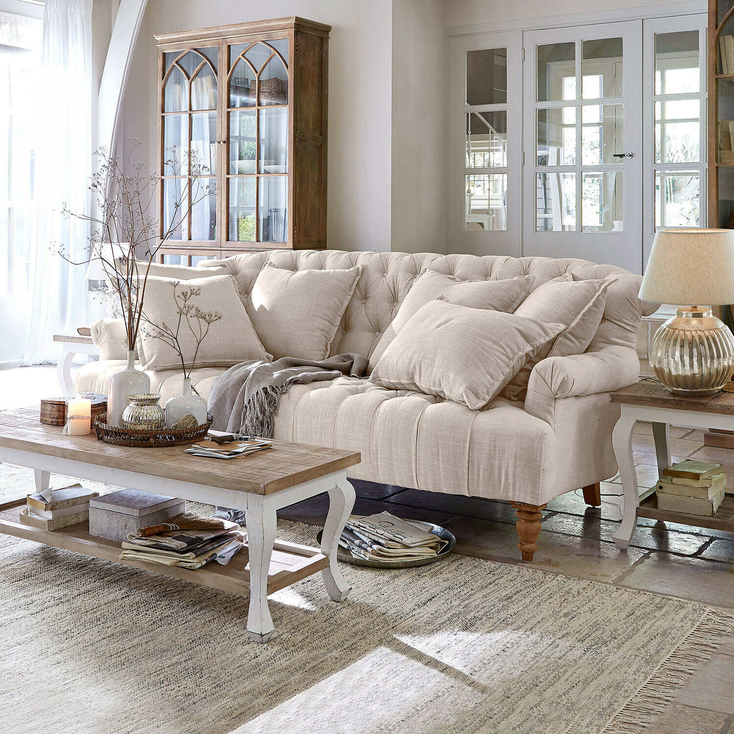 Sofa Springfield Village Beżowa tapicerowana sofa z poduszkami i drewnianym stolikiem kawowym w jasnym salonie