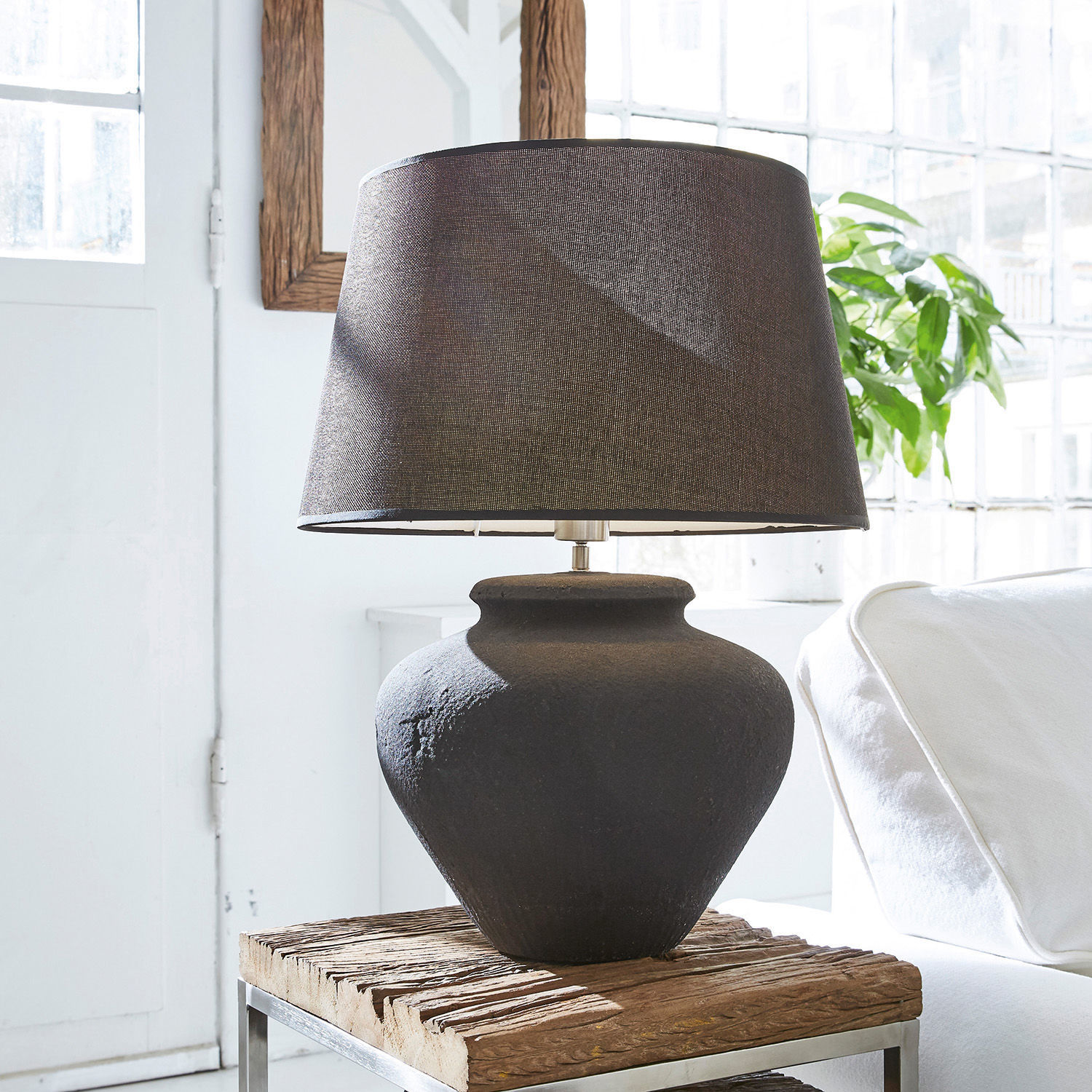 Lampa stołowa Bandol Czarna ceramiczna lampa stołowa z tekstylnym abażurem na drewnianym stoliku w jasnym wnętrzu