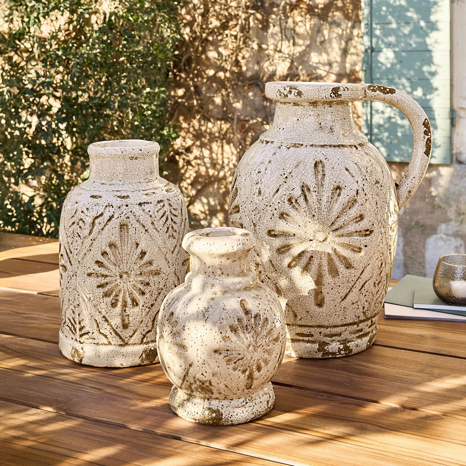 Wazon, zestaw 3 szt. Orsémine Zestaw trzech ceramicznych wazonów w kremowym kolorze z brązowymi wzorami na drewnianym stole na zewnątrz