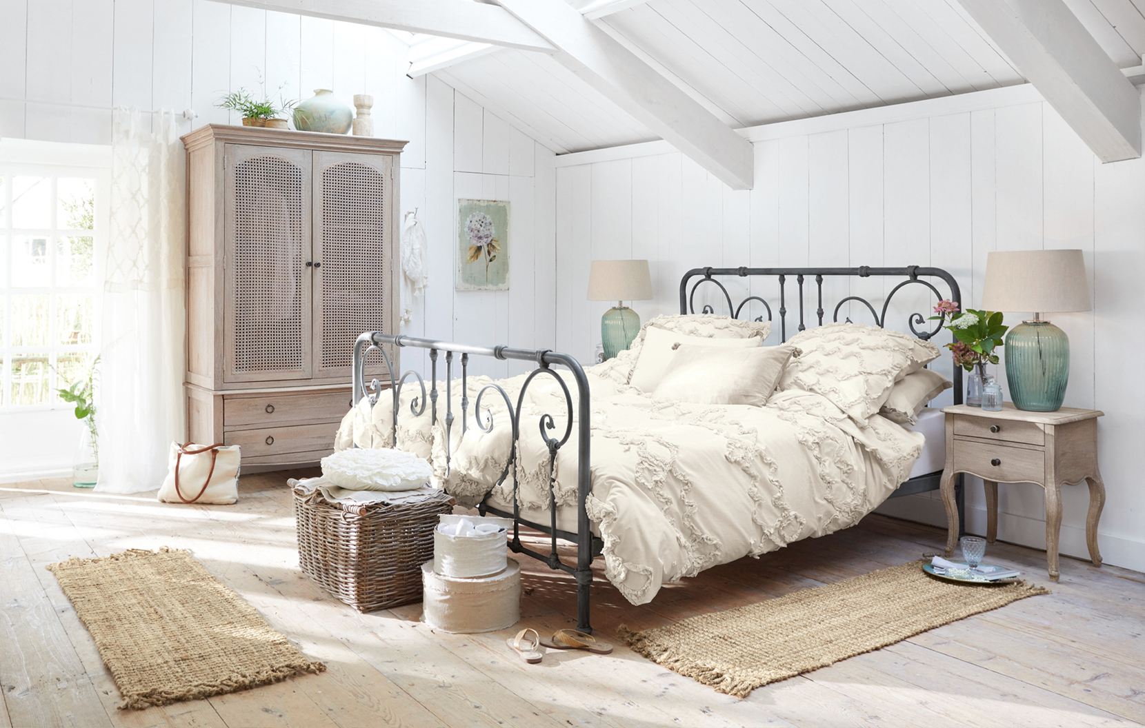 Sypialnia w stylu shabby chic z metalowym łóżkiem i kremową pościelą z bawełny, naturalne dodatki