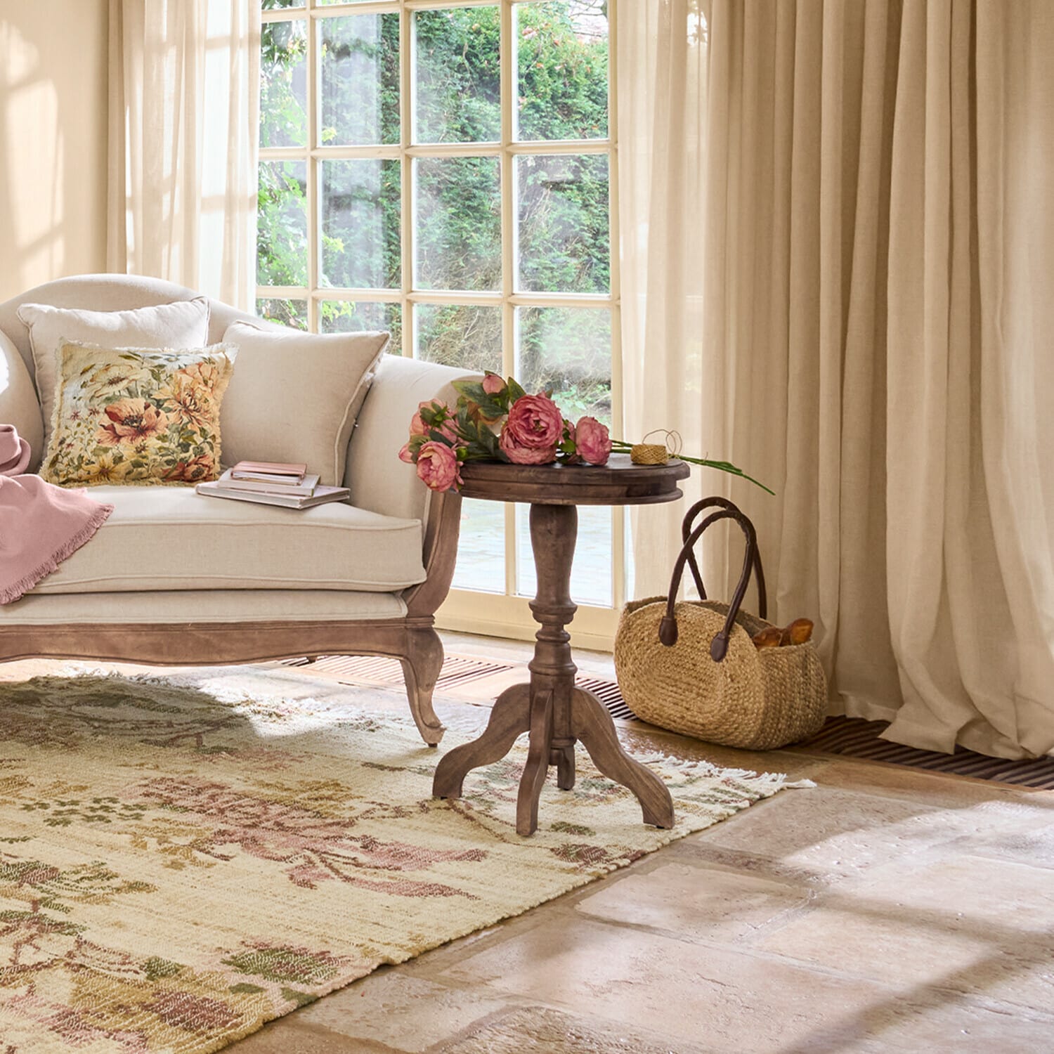 Przytulny salon z beżową sofą, drewnianym stolikiem i kwiatami na dywanie z wzorem kwiatowym