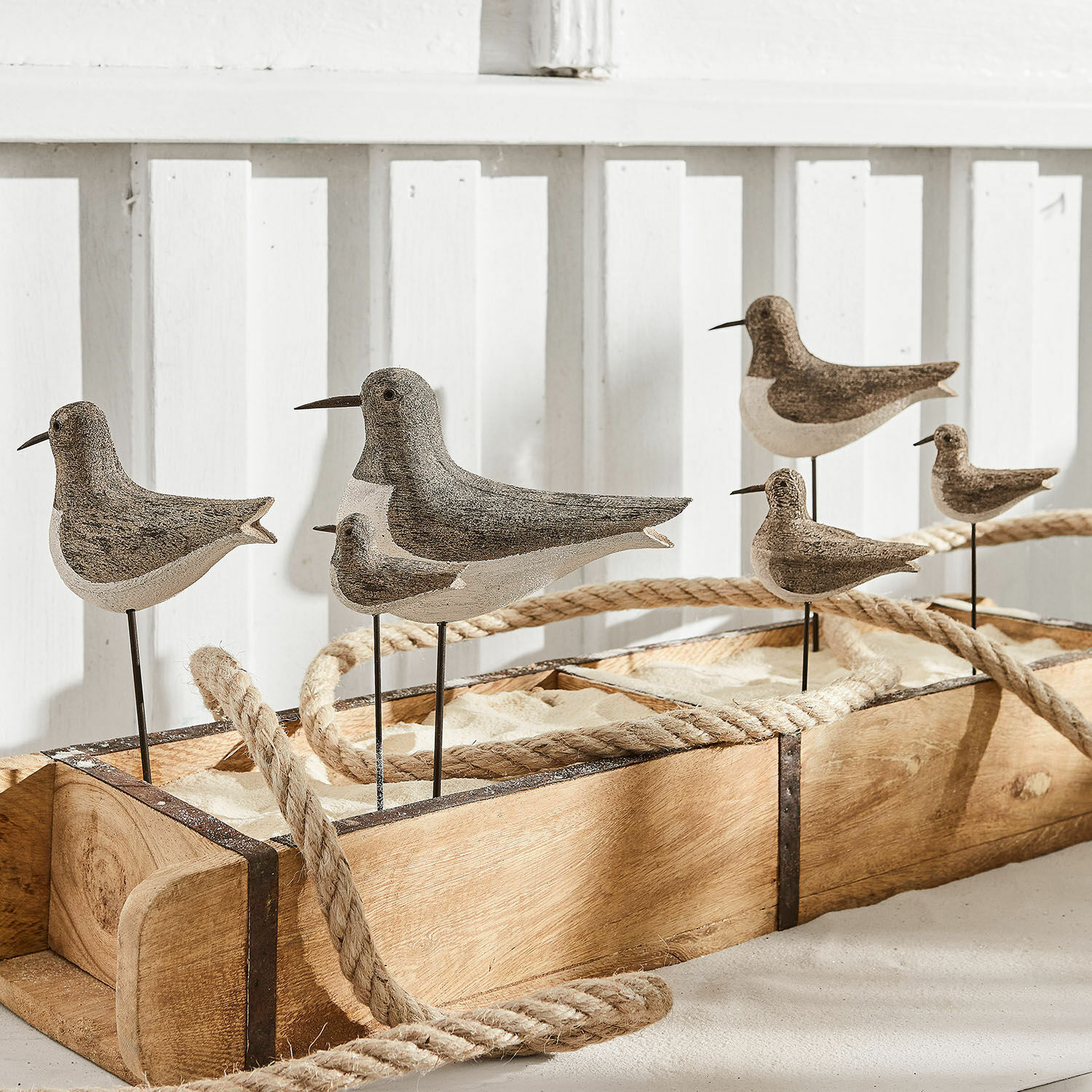 Dekoracyjne ptaki z drewna i metalu w naturalnych kolorach na drewnianej podstawie z piaskiem