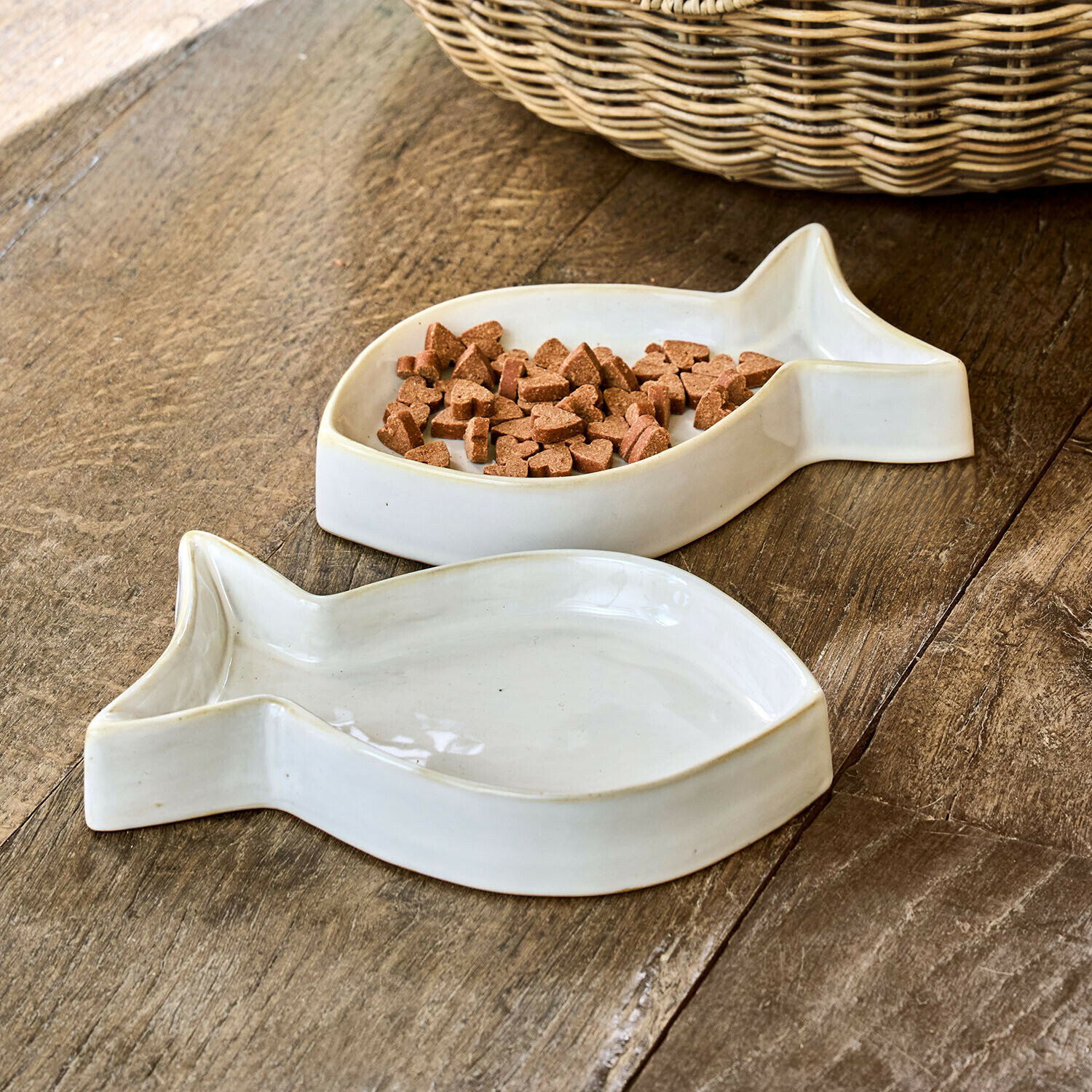 Ceramiczne białe miski w kształcie ryby na karmę dla zwierząt na drewnianym stole