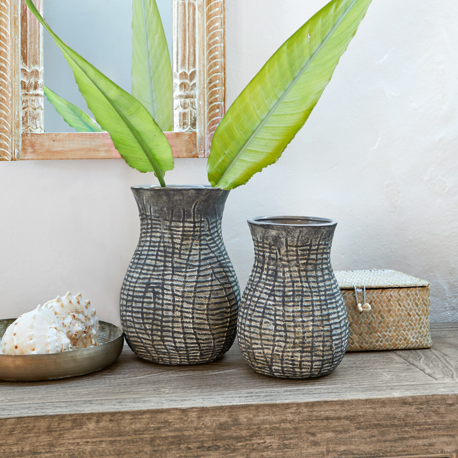Wazon, zestaw 2 szt. Fahrid Dwie ceramiczne wazony w szaro-czarnym kolorze z teksturowanym wzorem na drewnianym stole z zielonymi liśćmi