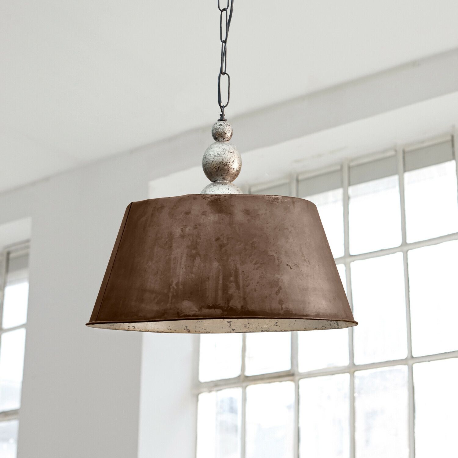 Lampa wisząca Chatel Dwie wiszące lampy z metalu w kolorze mosiądzu nad jasnym stołem jadalnym z dekoracjami i naczyniami