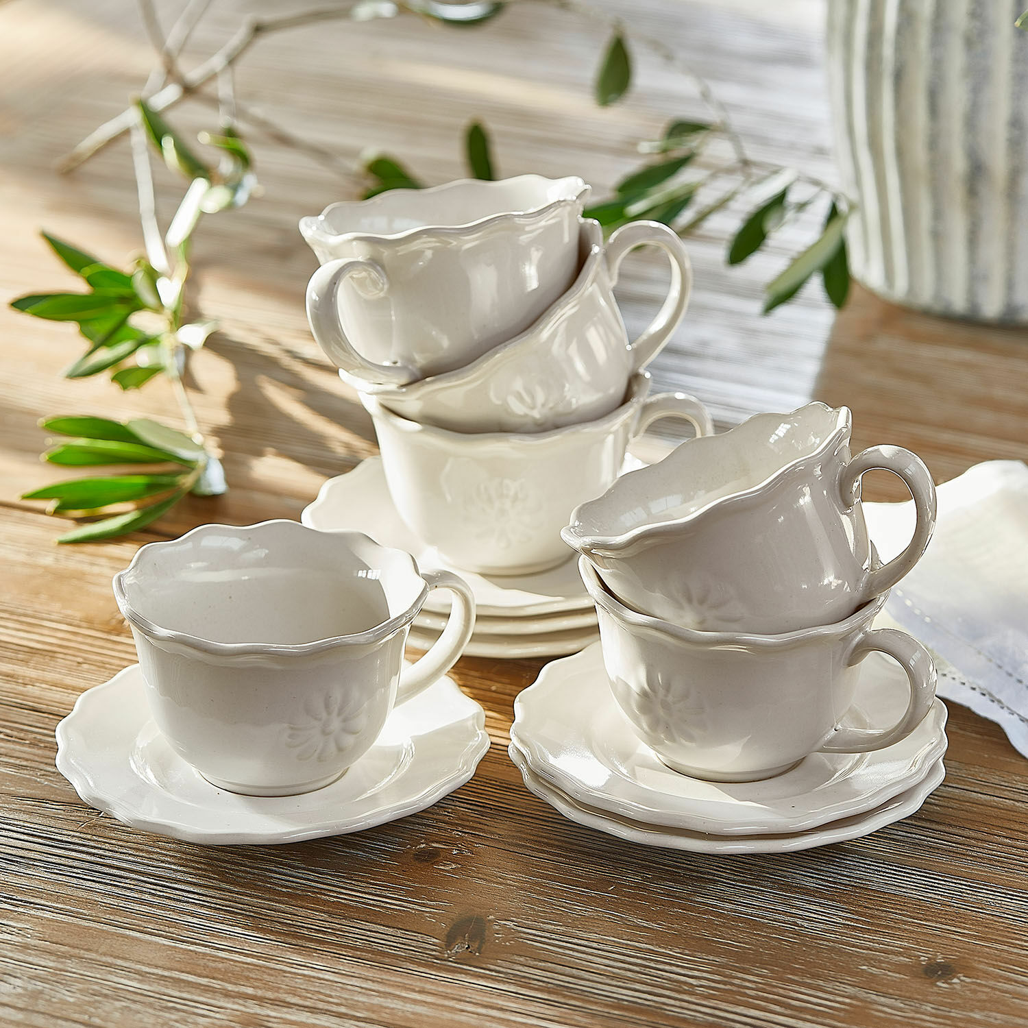 Zestaw filiżanek ze spodkami, 6 szt. Mallevesse Zestaw białych ceramicznych filiżanek i spodków z delikatnym wzorem na drewnianym stole