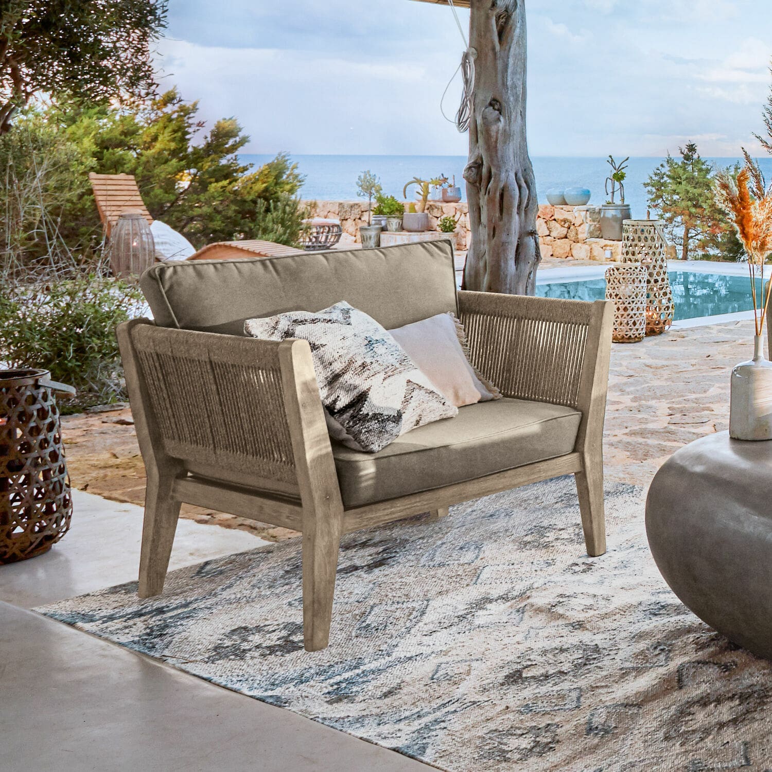 Fotel 100% FSC® Biarritz Sofa ogrodowe z drewna i tkaniny w kolorze beżowym na tarasie z widokiem na morze