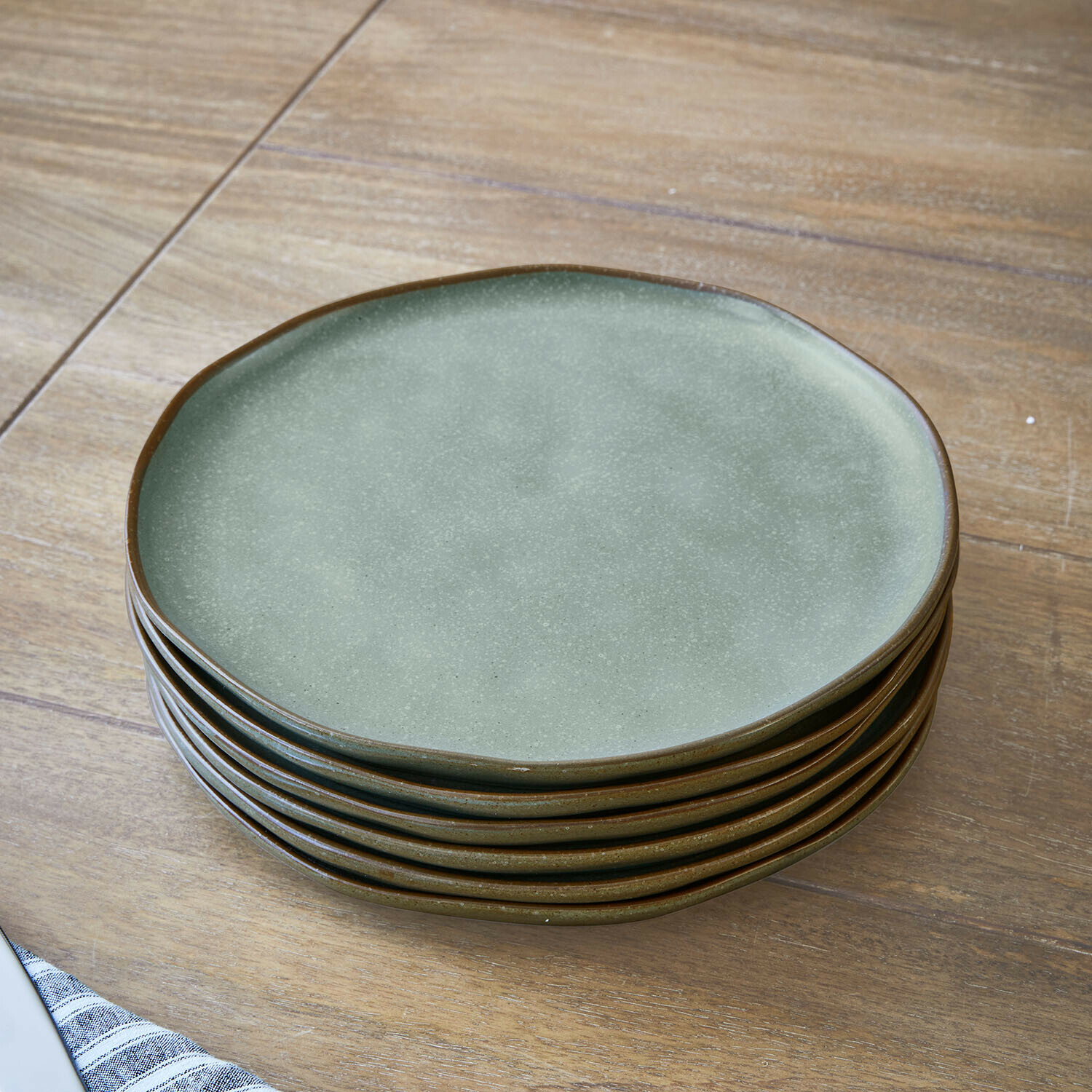 Talerz, zestaw 6 szt. Biarré Zestaw zielonych ceramicznych talerzy z brązową krawędzią na drewnianym stole, naczynia kuchenne