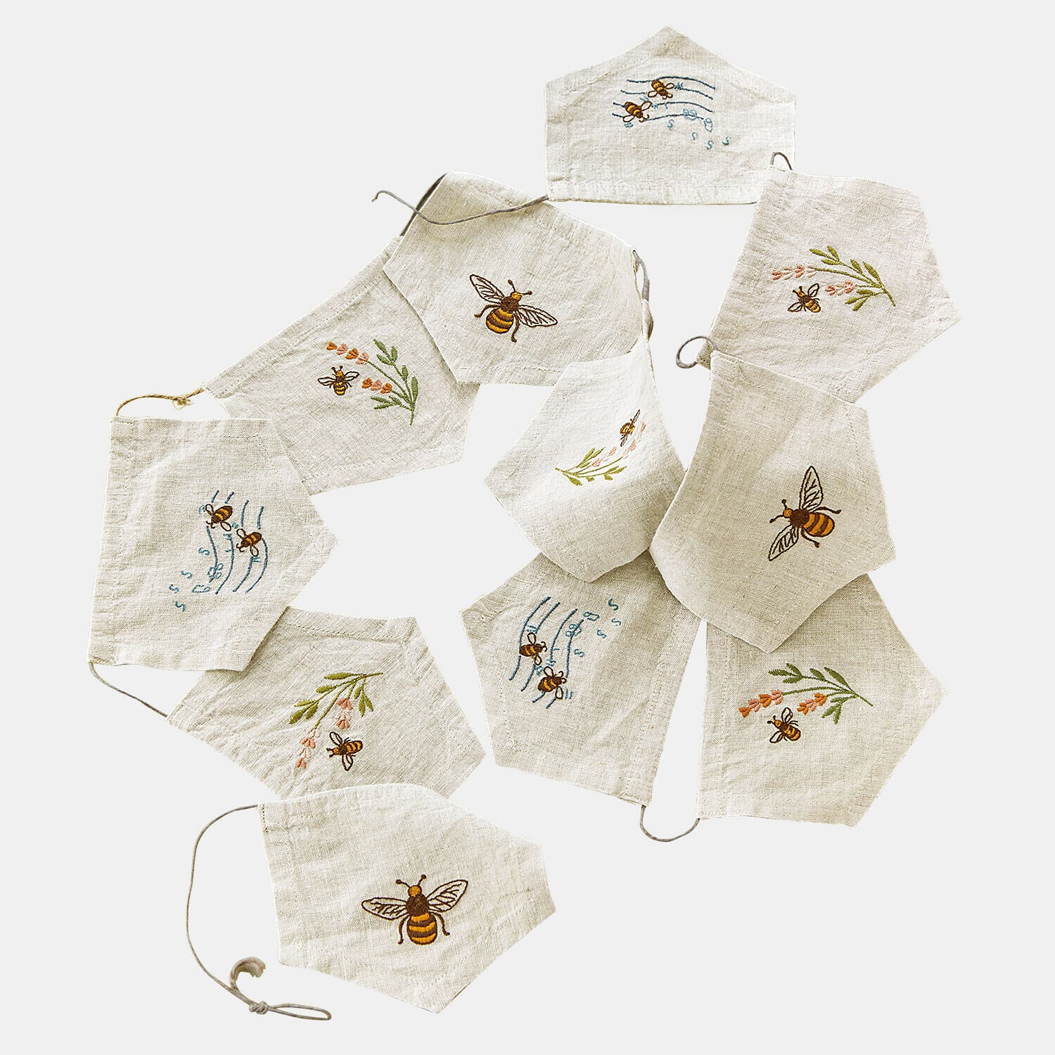 Lniane maseczki ochronne w jasnym kolorze z haftowanymi pszczołami i kwiatowymi motywami, zestaw dekoracyjny