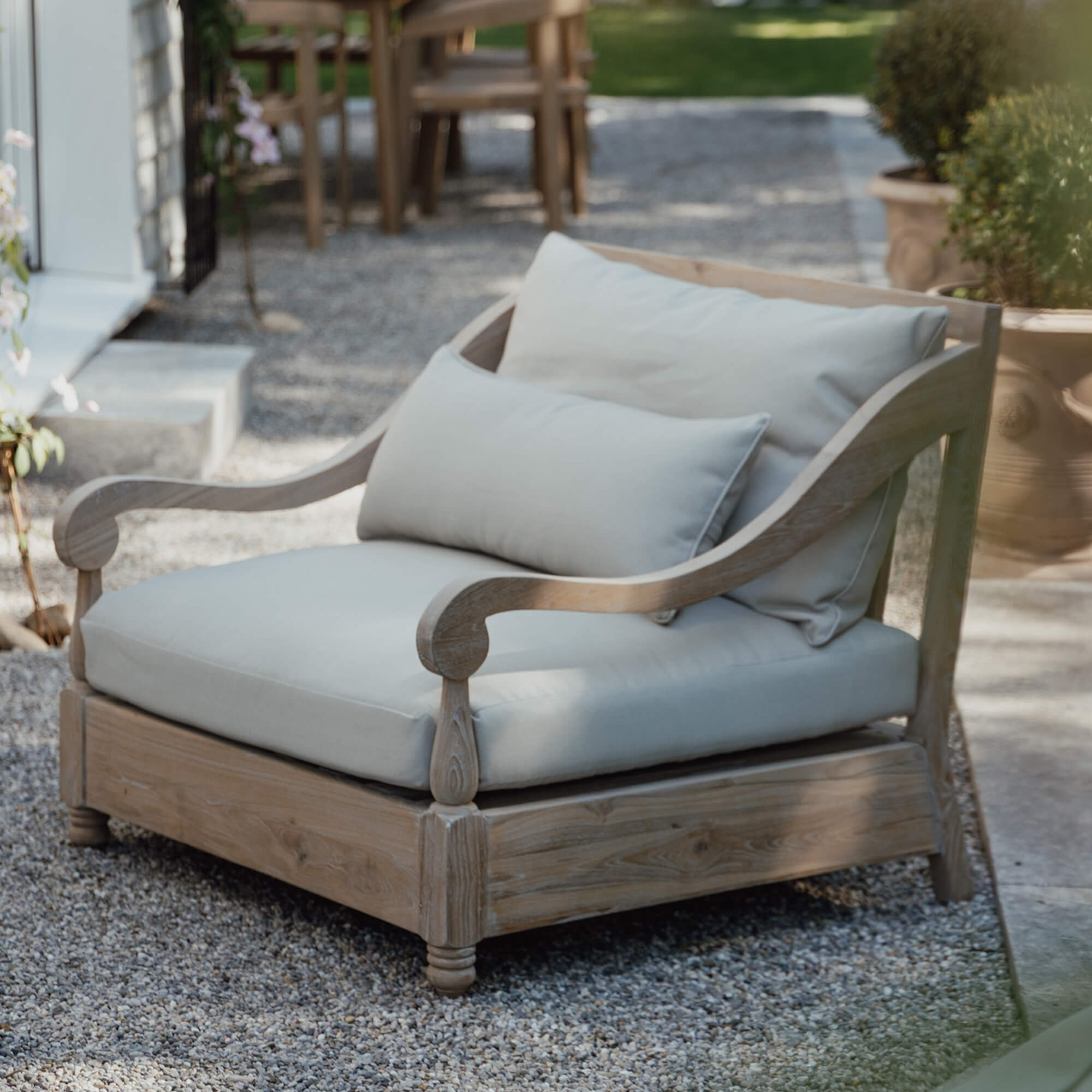 Sofa ogrodowe z jasnego drewna z kremowymi poduszkami, wygodne meble tarasowe