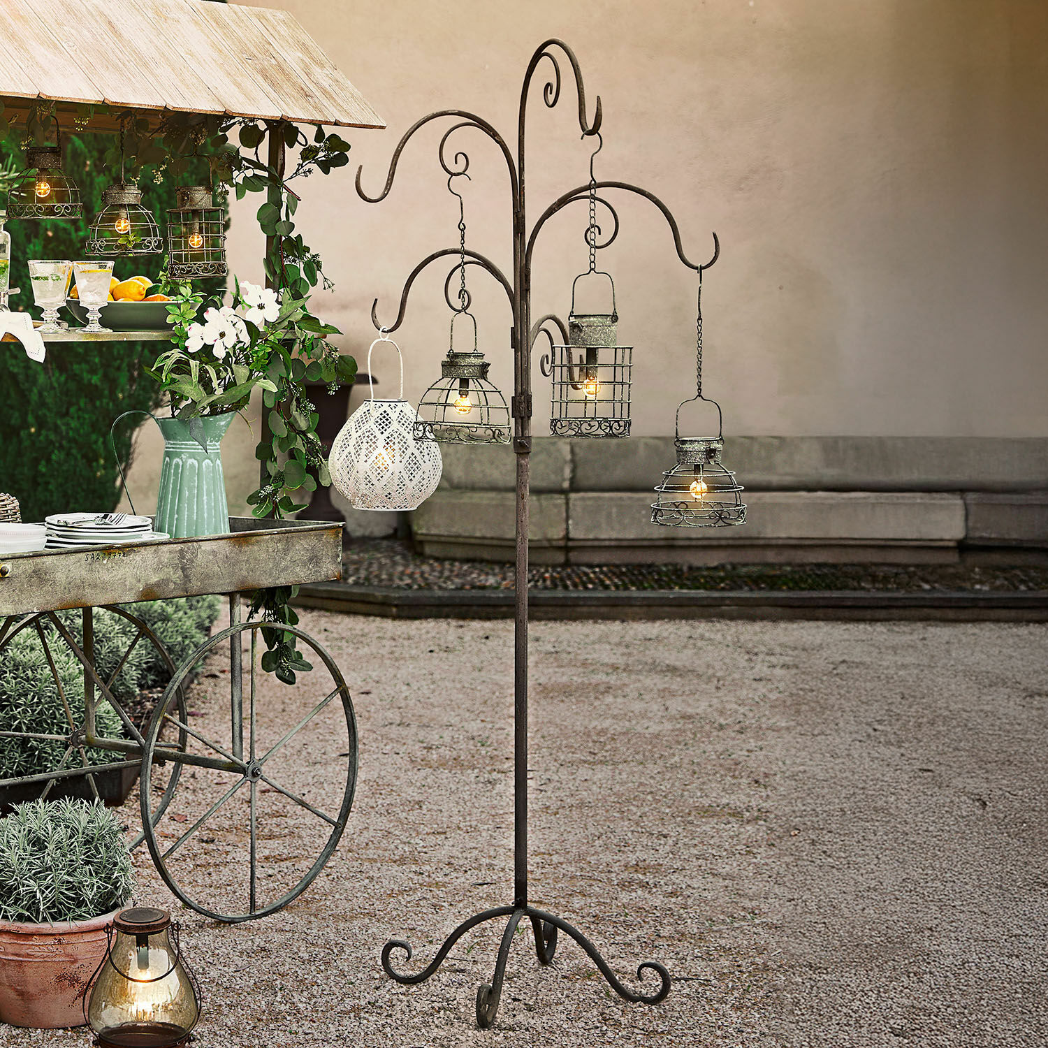 Stojak Merisette Metalowy stojak z czterema wiszącymi lampionami w stylu vintage do dekoracji ogrodu i tarasu