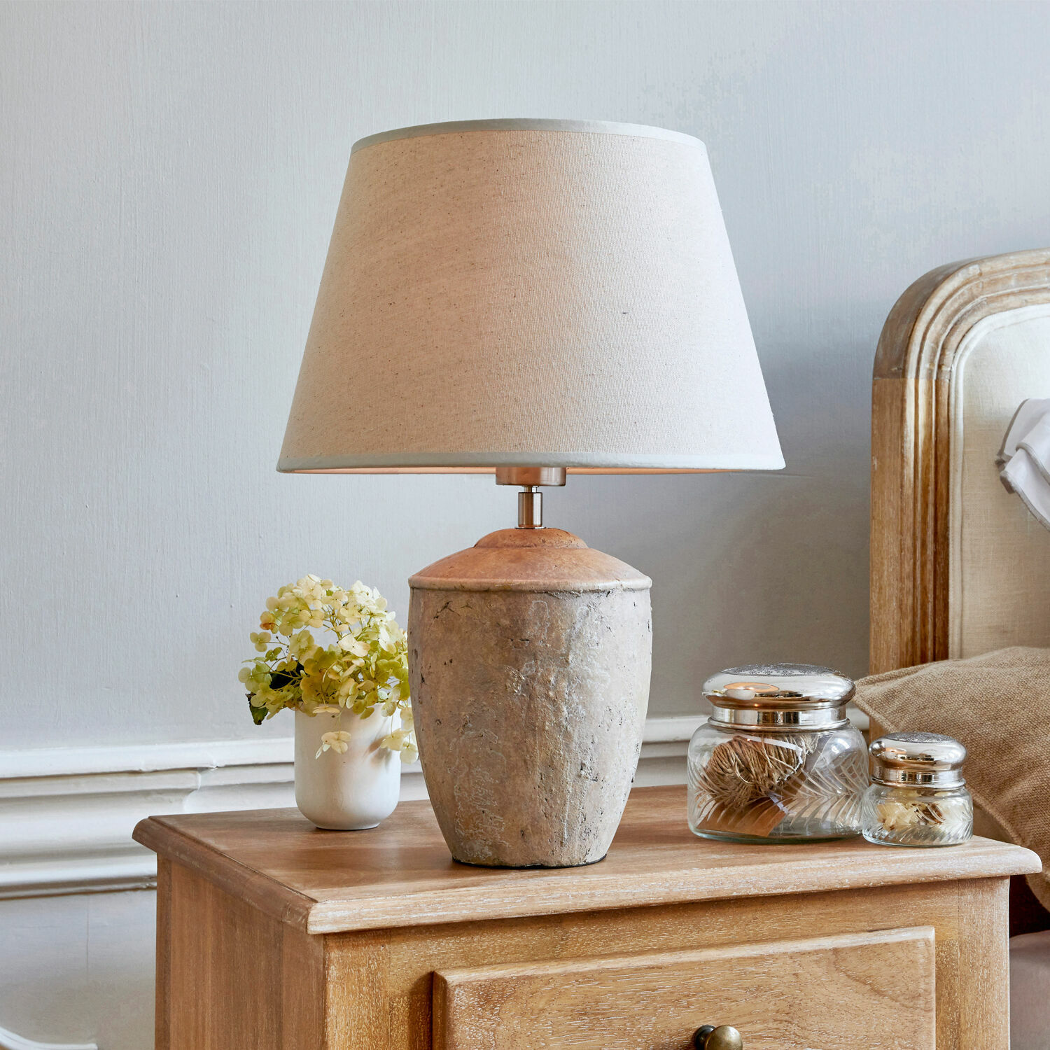 Lampa stołowa Verfaille Lampka stołowa z beżowym abażurem i ceramiczną podstawą na drewnianym stoliku nocnym